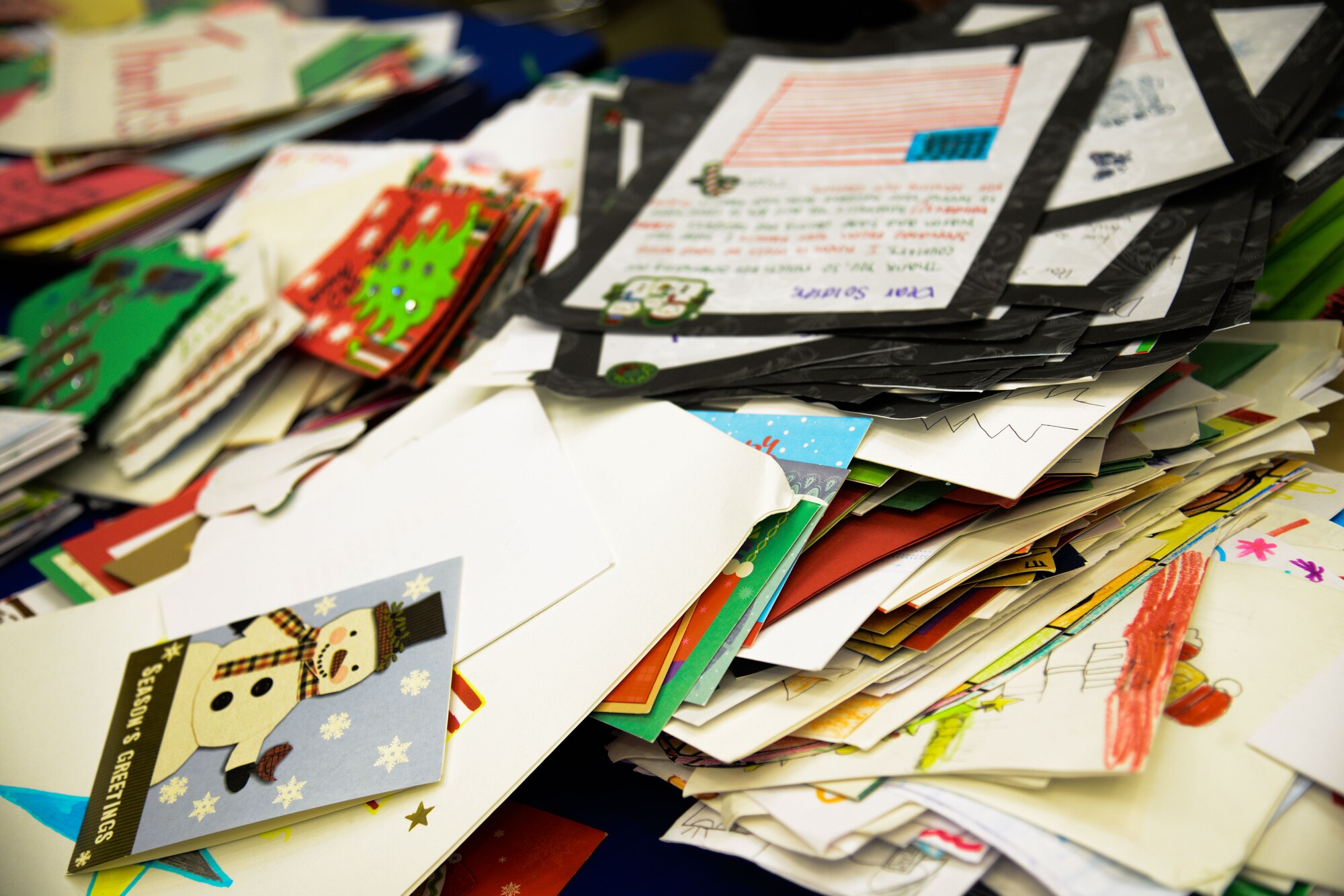Christmas cards rest in stacks during Operation Sweet Treat at Osan Air Base, Republic of Korea, Dec. 5, 2015. Team Osan volunteers and Osan Middle School children decorated the cards to give with bags of cookies to unaccompanied Airmen living in dormitories. (U.S. Air Force photo/Airman 1st Class Dillian Bamman) 