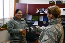 Tech. Sgt. Alena Arce, NCO in charge of 51st Fighter Wing executive staff, receives a bag of cookies from Master Sgt. Christine Wagner, 51st Wing Staff Agency first sergeant, during Operation Sweet Treat at Osan Air Base, Republic of Korea, Dec. 8, 2015. Team Osan volunteers baked more than 108,000 cookies for commanders and first sergeants to deliver to the base’s unaccompanied Airmen. (U.S. Air Force photo/Airman 1st Class Dillian Bamman)