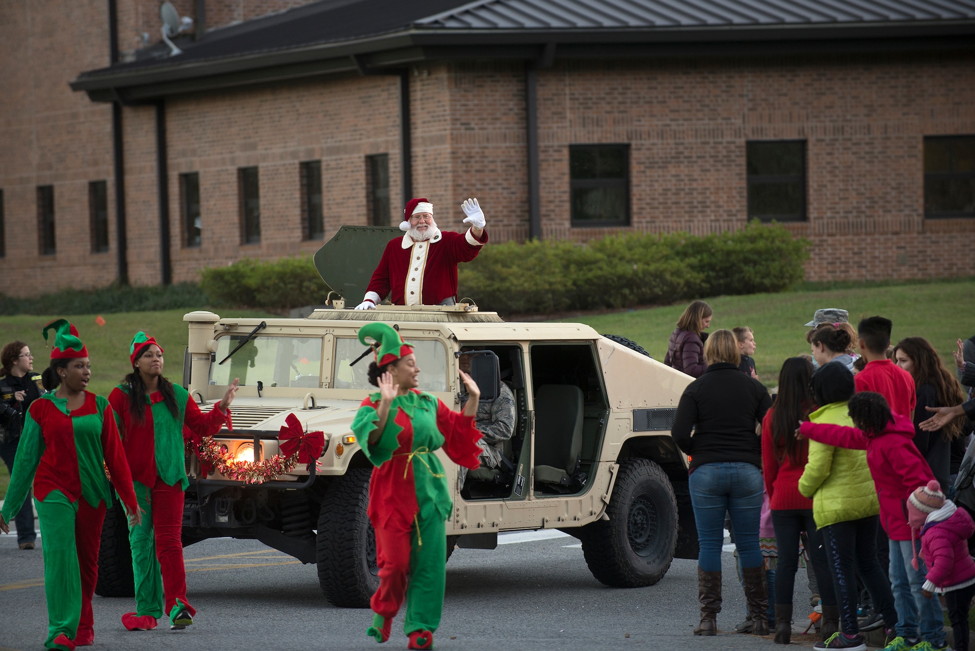 Santa Claus waves to the crowd during a parade held at the annual tree-lighting event, Dec. 4, 2015, at Moody Air Force Base, Ga. Claus followed base leadership as they threw out candy to the crowd. (U.S. Air Force photo by Airman Daniel Snider/released)