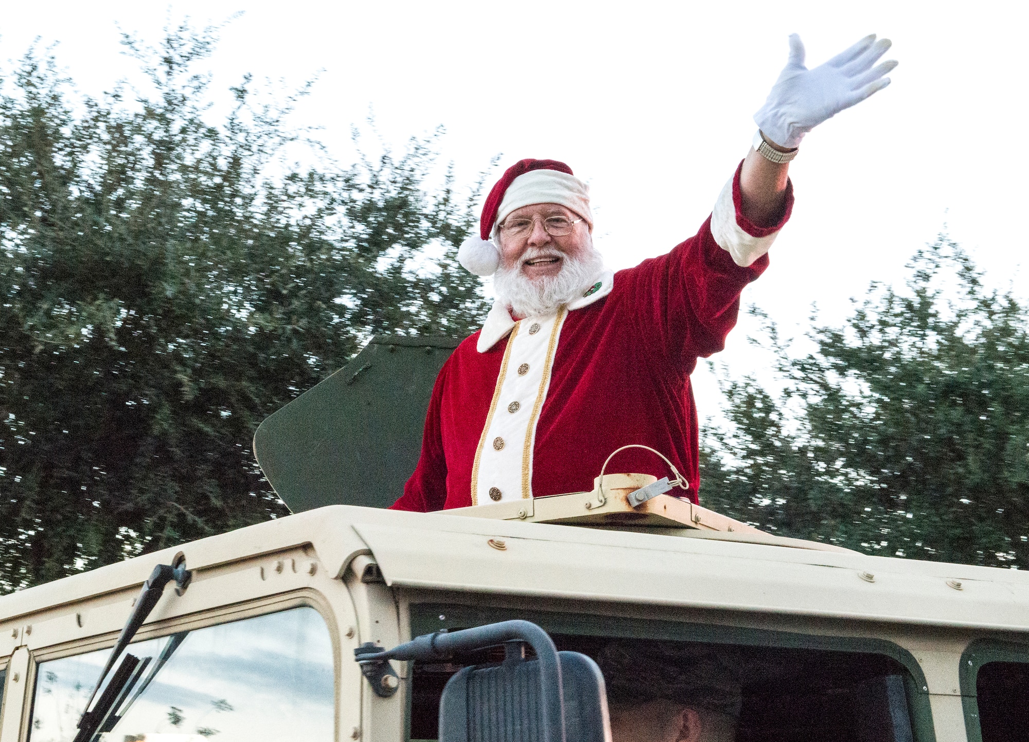 Santa Claus waves to the crowd at the annual tree lighting ceremony, Dec. 4, 2015, at Moody Air Force Base, Ga. Mr. Claus made his grand entrance from the top of a Humvee at the end of the holiday parade. (U.S. Air Force photo by Airman 1st Class Lauren M. Johnson/Released)
