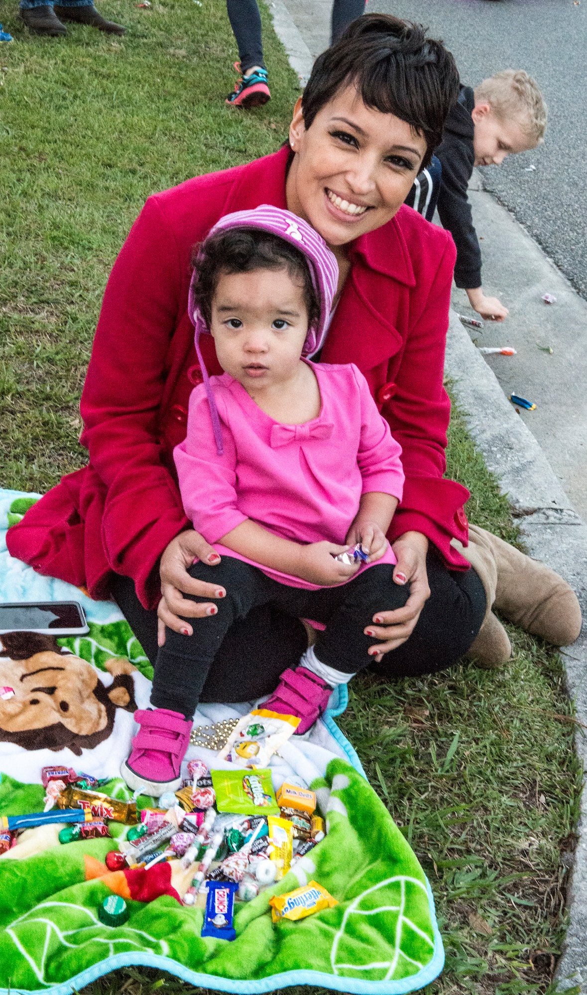 Eduviges Warner and her daughter, Apalonia, pose for a photo at the annual tree lighting ceremony, Dec. 4, 2015, at Moody Air Force Base, Ga. Apalonia watched the parade from the sideline and collected candy passed out by parade participants. (U.S. Air Force photo by Airman 1st Class Lauren M. Johnson/Released)