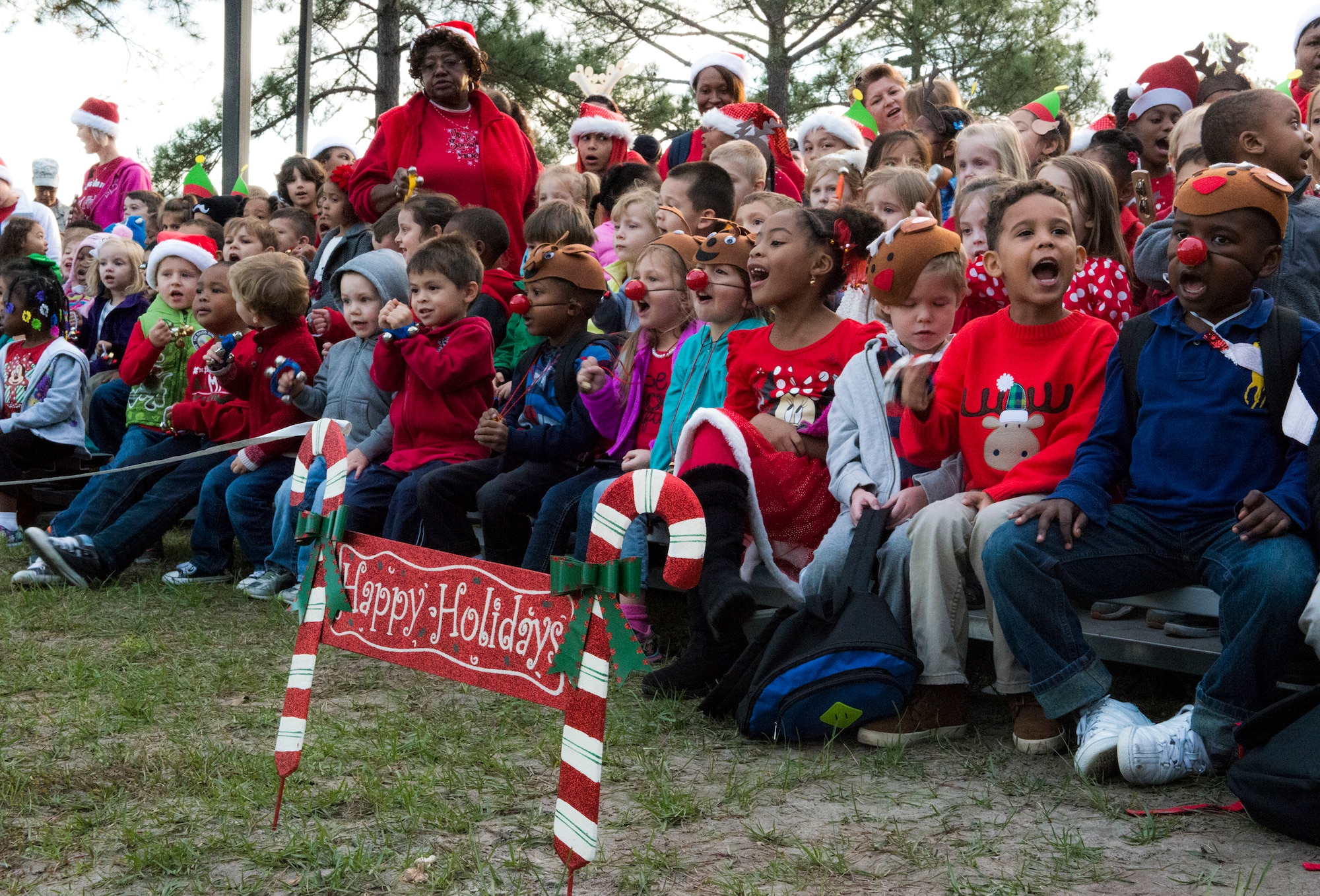 Children from the Child Development Center sing holiday songs to the crowd during the annual tree lighting ceremony, Dec. 4, 2015, at Moody Air Force Base, Ga. The children spent many hours practicing songs such as “Santa Claus is Coming to Town,” “Jingle Bells” and “We Wish You a Merry Christmas.” (U.S. Air Force photo by Airman 1st Class Lauren M. Johnson/Released)
