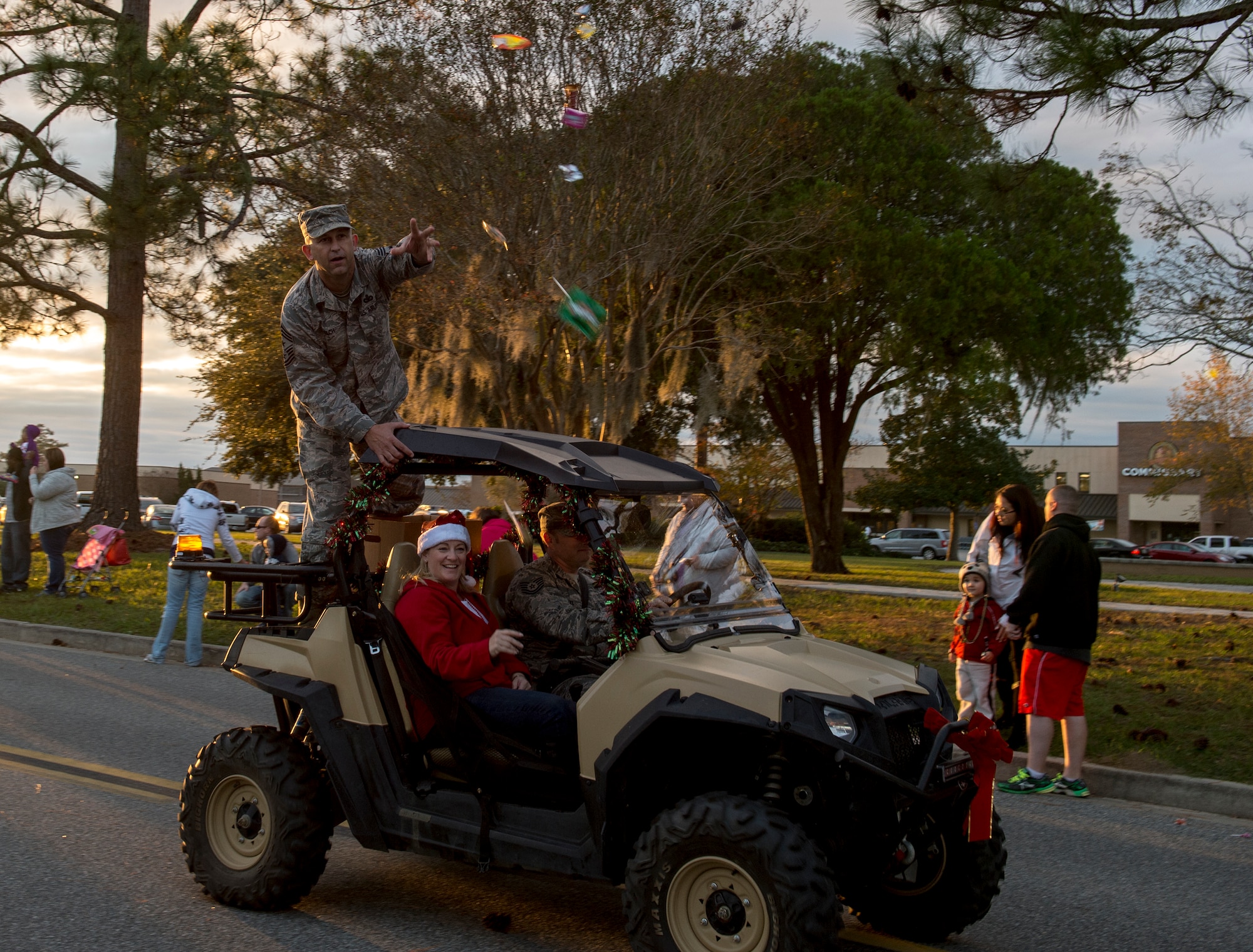 Chief Master Sgt. David Kelch, 23d Wing command chief, throws candy to attendees of the tree-lighting ceremony, Dec. 4, 2015, at Moody Air Force Base, Ga. Members of leadership and different base and community organizations marched in a parade and tossed candy to the crowd before lighting the tree. (U.S. Air Force photo/Tech. Sgt. Zachary Wolf)