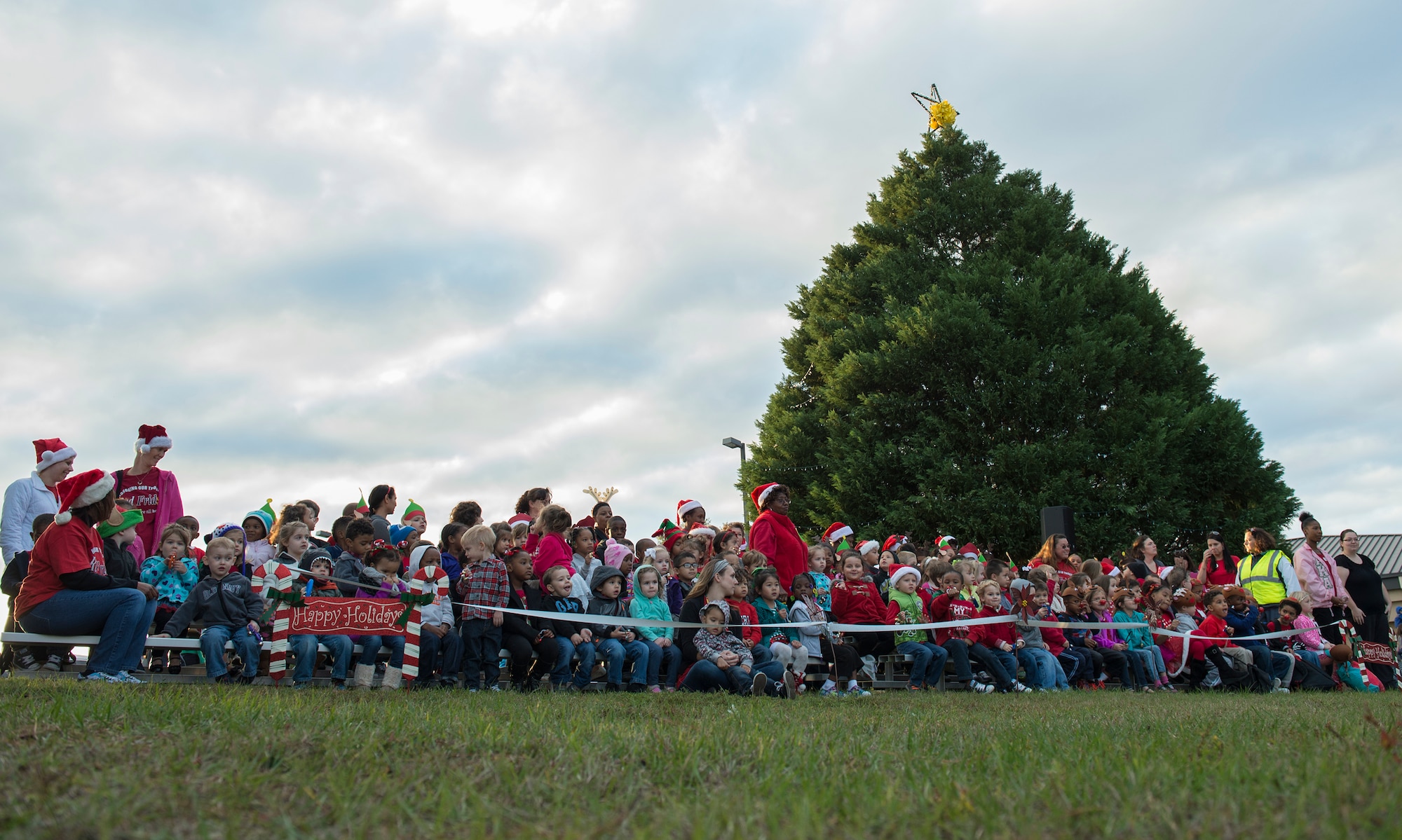 Children from the youth center sing to a crowd during the tree-lighting ceremony, Dec. 4, 2015, at Moody Air Force Base, Ga. The children sang a few songs before a parade and the lighting of the tree. (U.S. Air Force photo/Tech. Sgt. Zachary Wolf)