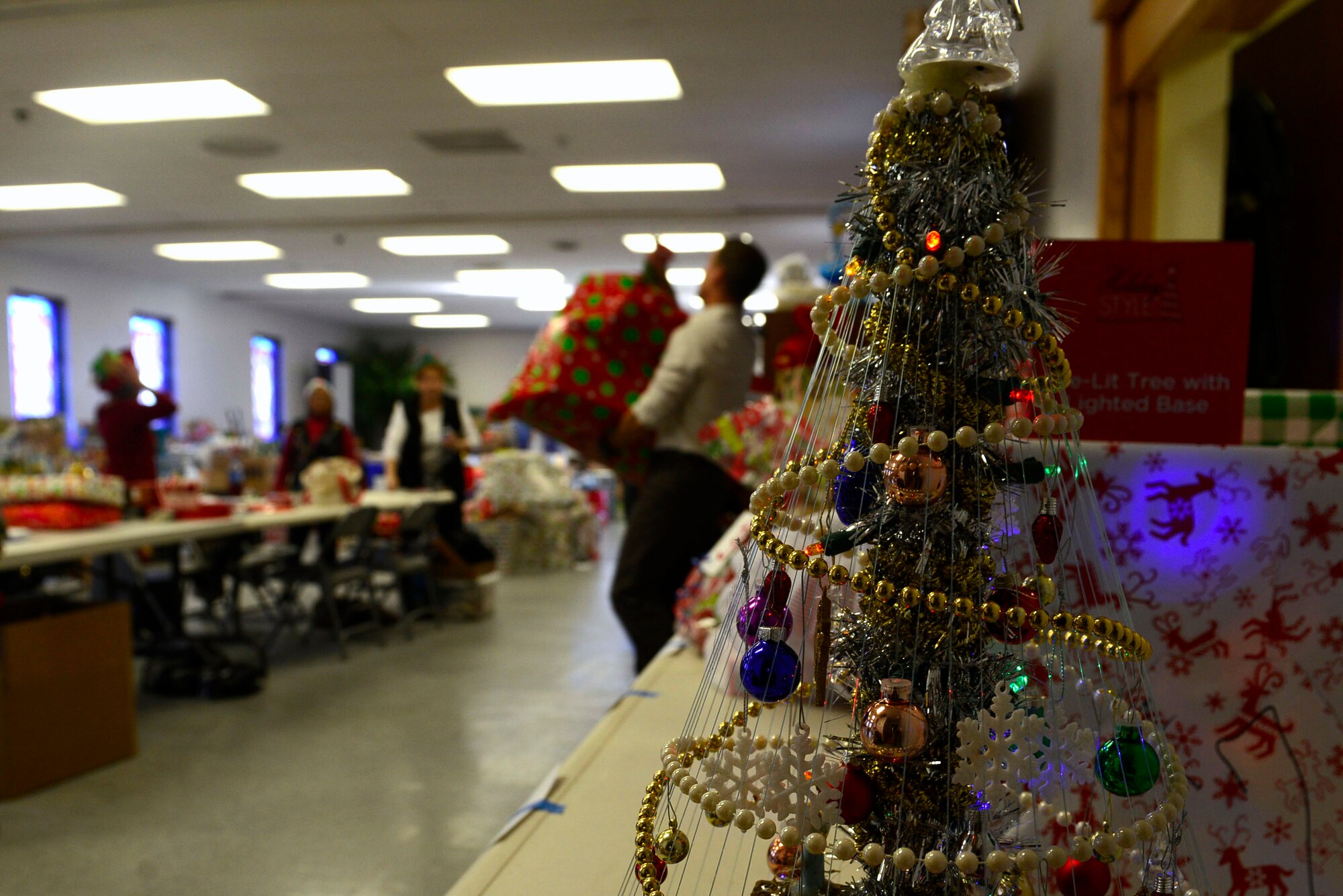 A sponsor  carries a gift parcel for his assigned family at the Palmetto Chapel in support of Operation True Giving at Shaw Air Force Base, S.C., Dec. 4, 2015. Sponsors care for families by provding a Christmas meal and  gifts the family might need for the holiday season. (U.S. Air Force photo by Airman 1st Class Christopher Maldonado)