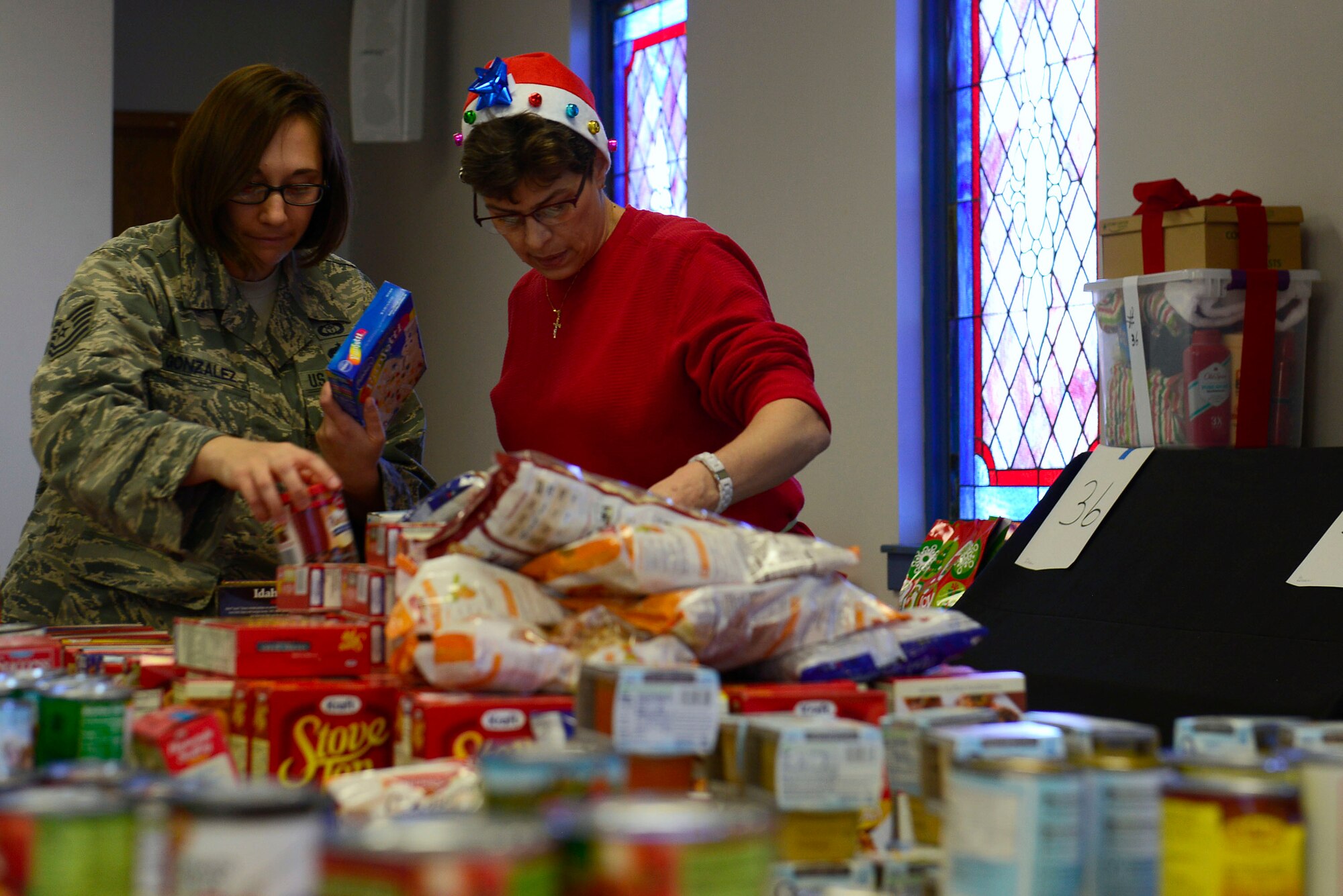 Volunteers organize non-perishable goods at the Palmetto Chapel in support of Operation True Giving at Shaw Air Force Base, S.C., Dec. 4, 2015. Operation True Giving will help 83 families have a bright Christmas by providing  food, clothing, and many great gifts. (U.S. Air Force photo by Airman 1st Class Christopher Maldonado)
