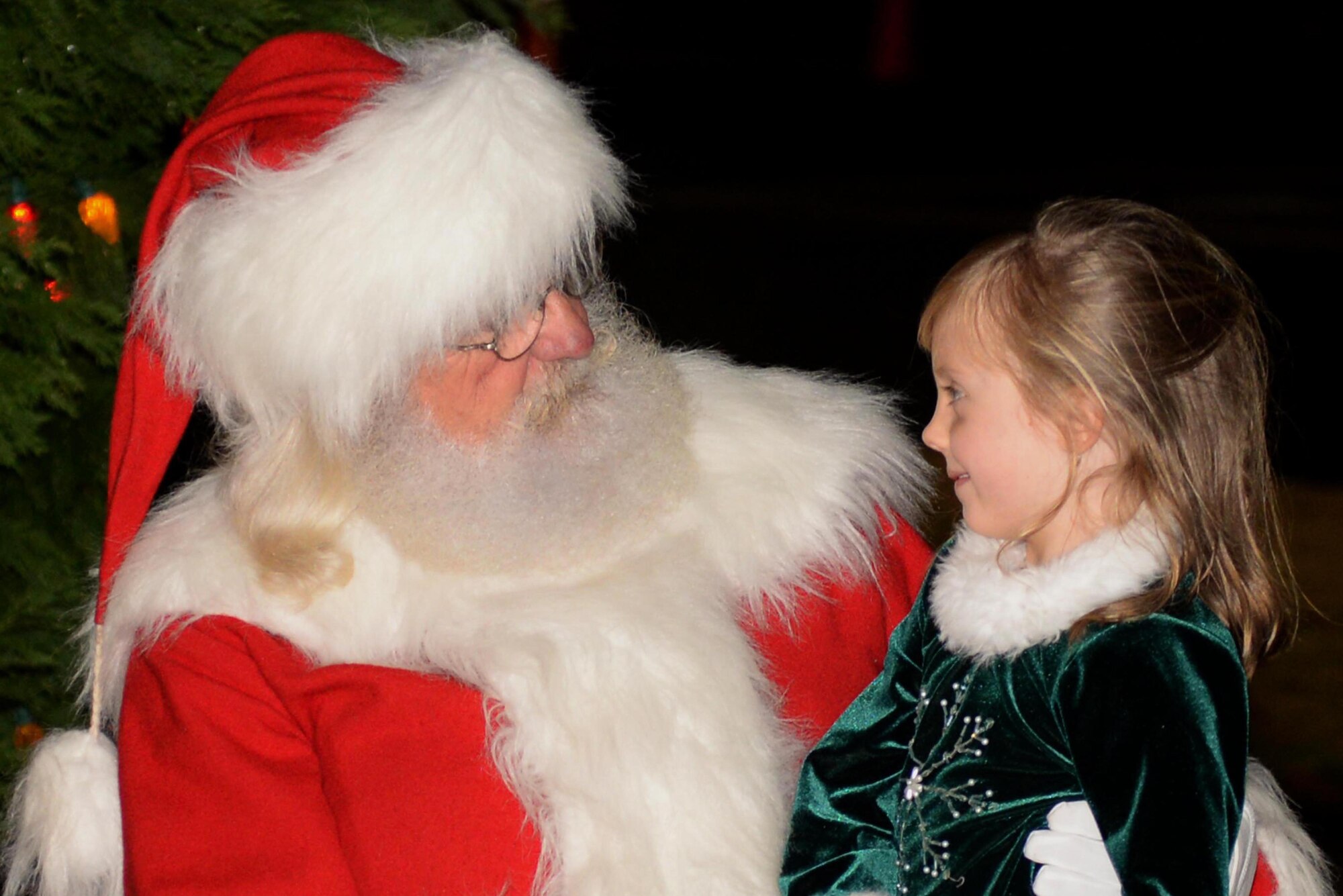 A young member of Team Seymour sits on Santa’s lap during a tree lighting ceremony, Dec. 7, 2015, at Seymour Johnson Air Force Base, North Carolina. Members of Team Seymour lined up to take photos with Santa, and participated in carriage rides and a holiday market. (U.S. Air Force photo/Airman 1st Class Ashley Williamson)