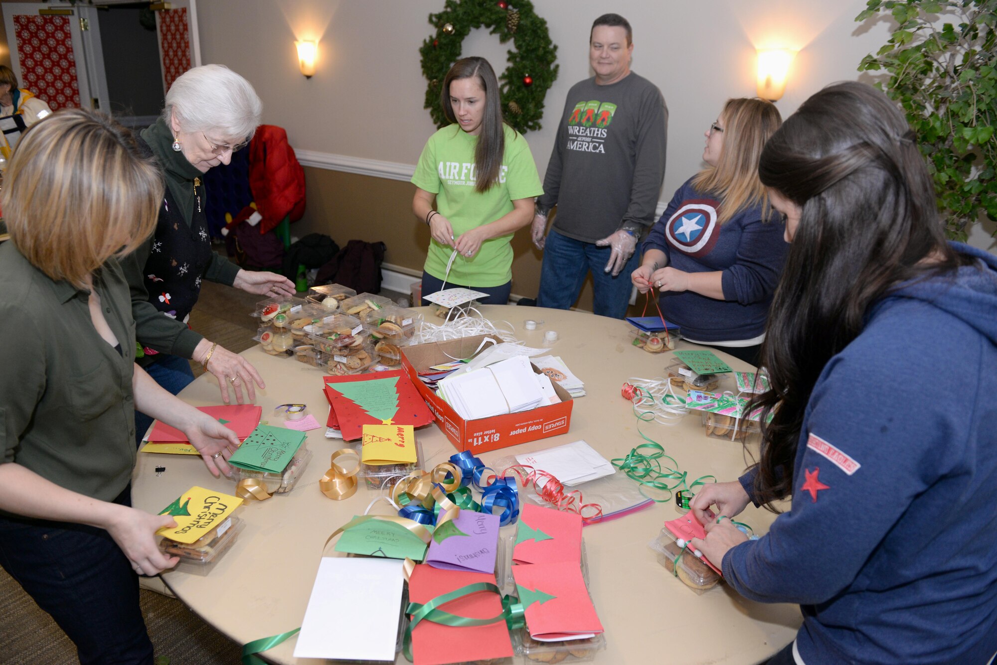 Volunteers tie holiday cards, made by local elementary and middle school students, to boxes of cookies, Dec. 7, 2015, at Seymour Johnson Air Force Base, North Carolina, during the annual cookie drive. Community and service members donated hundreds of cookies for Airmen living in the dorms. (U.S. Air Force photo/Airman 1st Class Ashley Williamson)