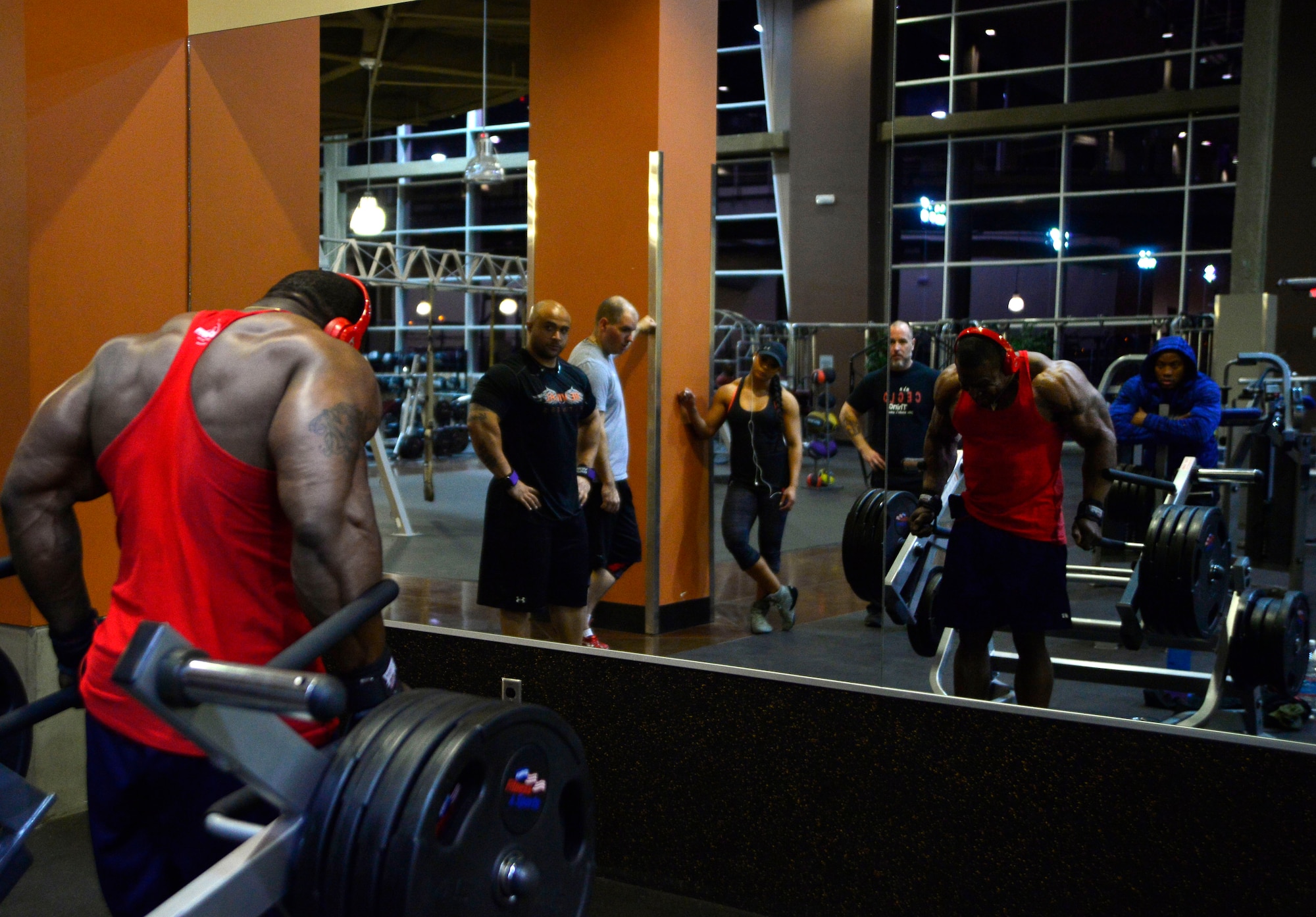 Tech. Sgt. David, 432nd Maintenance Group contract officer representative, performs shrugs while his training partners watch during a workout Dec. 4, 2015, at Nellis Air Force Base, Nevada. David has been training for six years to be a professional body builder and recently earned his professional status after taking second place overall at the 2015 National Physique Committee National Bodybuilding Championships on Nov. 21, 2015.(U.S. Air Force photo by Airman 1st Class Christian Clausen/Released)

