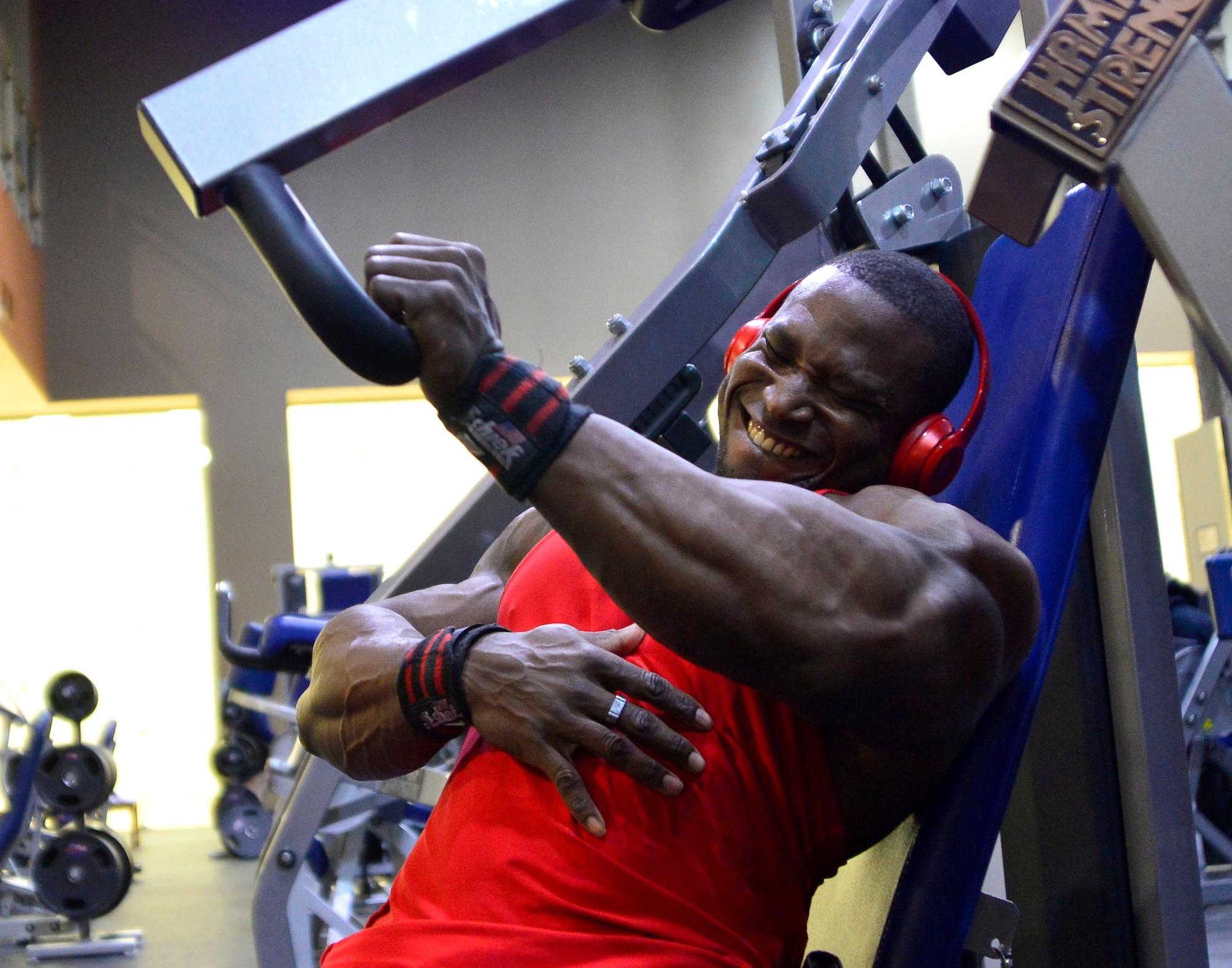 Tech. Sgt. David, 432nd Maintenance Group contract officer representative, performs one-arm chest presses during a workout Dec. 4, 2015, at Nellis Air Force Base, Nevada. David is a professional bodybuilder in the International Federation of Bodybuilding and Fitness. (U.S. Air Force photo by Airman 1st Class Christian Clausen/Released)