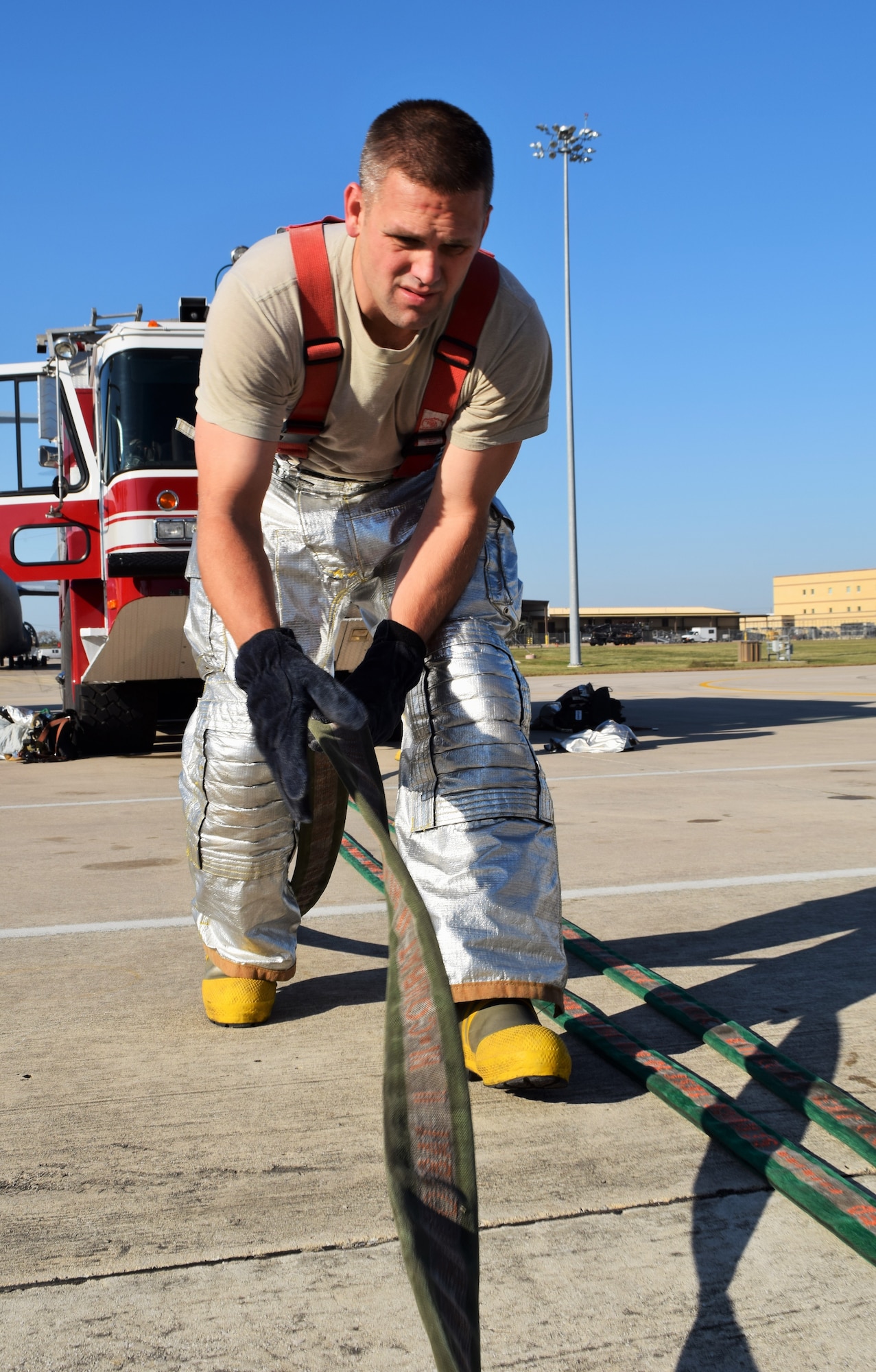 Tech. Sgt. Stephen Johnson, 433rd Civil Engineer Squadron firefighter, straightens a hose before storing it in a fire truck at the end of a C-5 egress training exercise Dec. 6, 2015 on the Joint Base San Antonio-Lackland flightline. The C-5 egress training is an annual requirement for the firefighters who were evaluated on their ability to extinguish simulated engine fires, shut off the aircraft, and conduct search and rescue. (U.S. Air Force photo/Tech. Sgt. Lindsey Maurice)