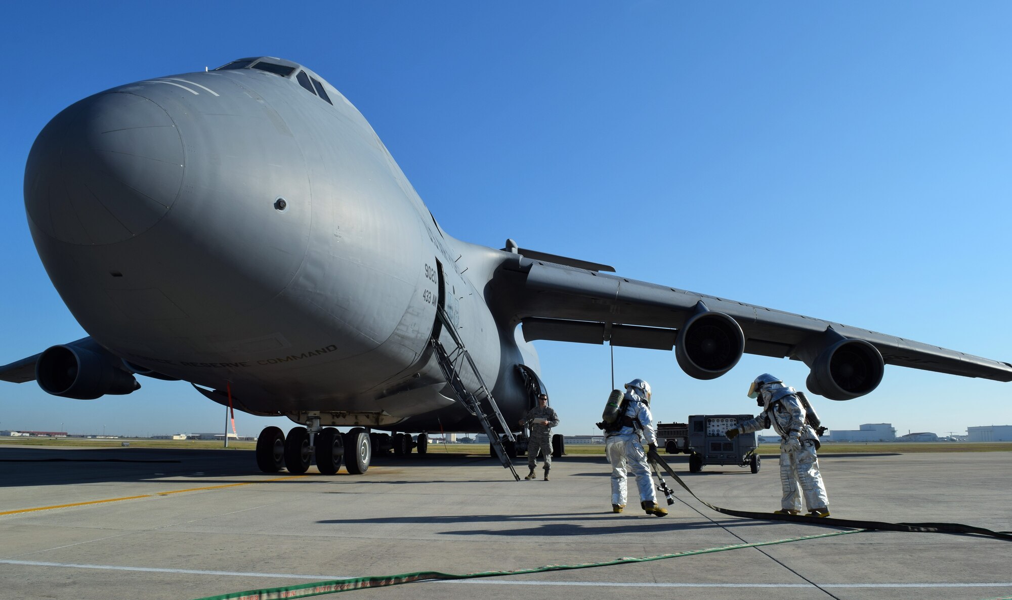 Firefighters with the 433rd Civil Engineer Squadron simulate extinguishing an engine fire on a C-5A Galaxy Dec. 6, 2015 on the Joint Base San Antonio-Lackland, Texas flightline. The C-5 egress training is an annual requirement for the firefighters who were evaluated on their response procedures, ability to extinguish the fire, conduct search and rescue and shut off the aircraft. (U.S. Air Force photo/Tech. Sgt. Lindsey Maurice)