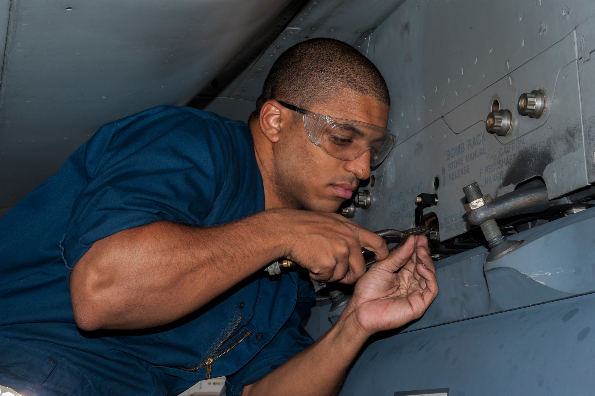 U.S. Air Force Airman 1st Class Brandon Martel, 67th Aircraft Maintenance Unit avionics technician apprentice, secures safety wire for a sniper pod on an F-15C Eagle, Dec. 8, 2015, at Kadena Air Base, Japan. The safety wire and attached pin ensure the sniper pod cannot be accidently jettisoned during flight. (U.S. Air Force photo by Airman Zackary A. Henry)