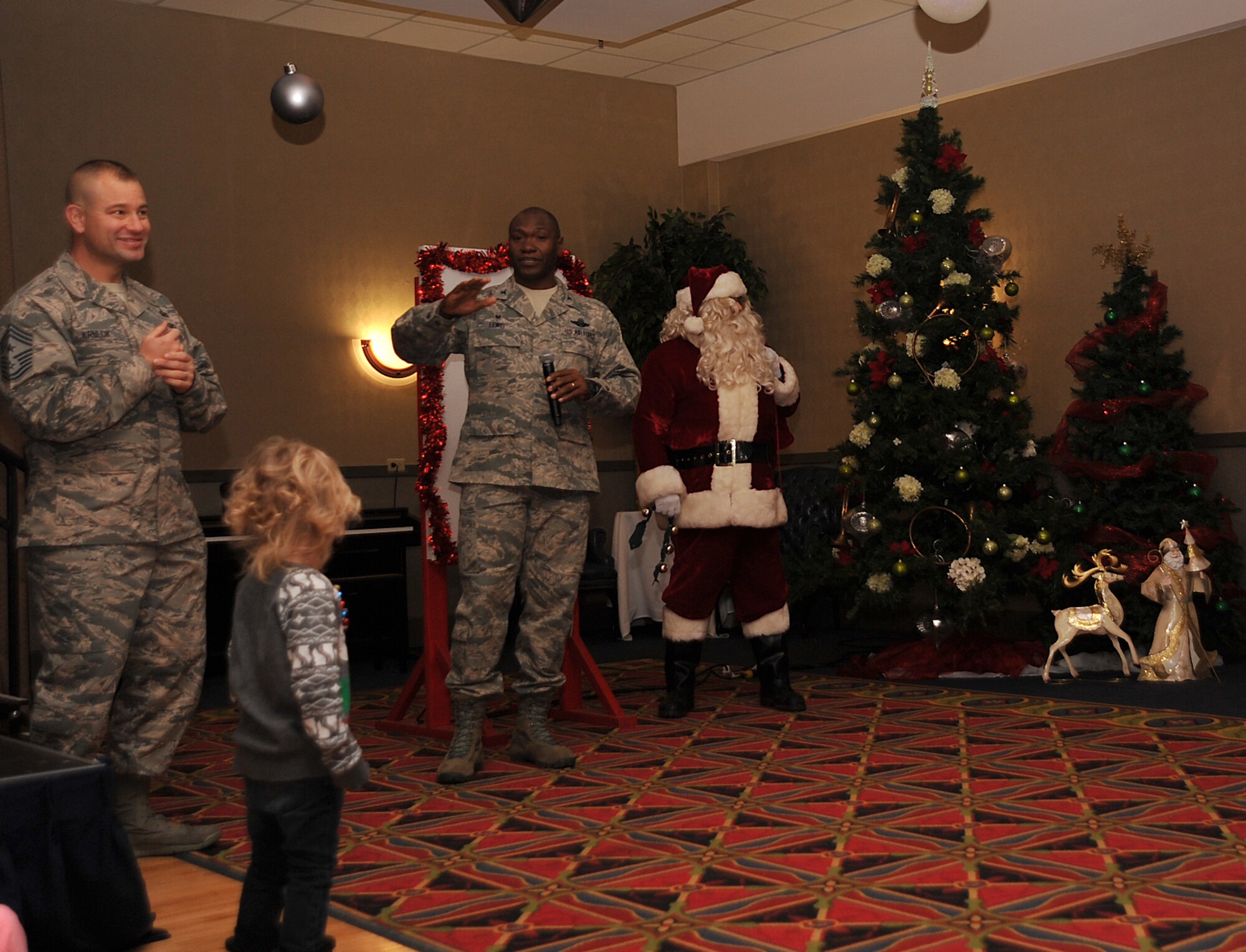 Col. Rodney Lewis, 319th Air Base Wing commander, greets the attendees at the Holiday Tree Lighting ceremony before lighting the tree with Chief Master Sgt. Todd Krulcik, 319th Air Base Wing command chief, and Santa Claus on Grand Forks Air Force Base, North Dakota, Dec. 7, 2015. The event is an annual event that signifies the beginning of the holidays. (U.S. Air Force photo by Senior Airman Bonnie Grantham/released)