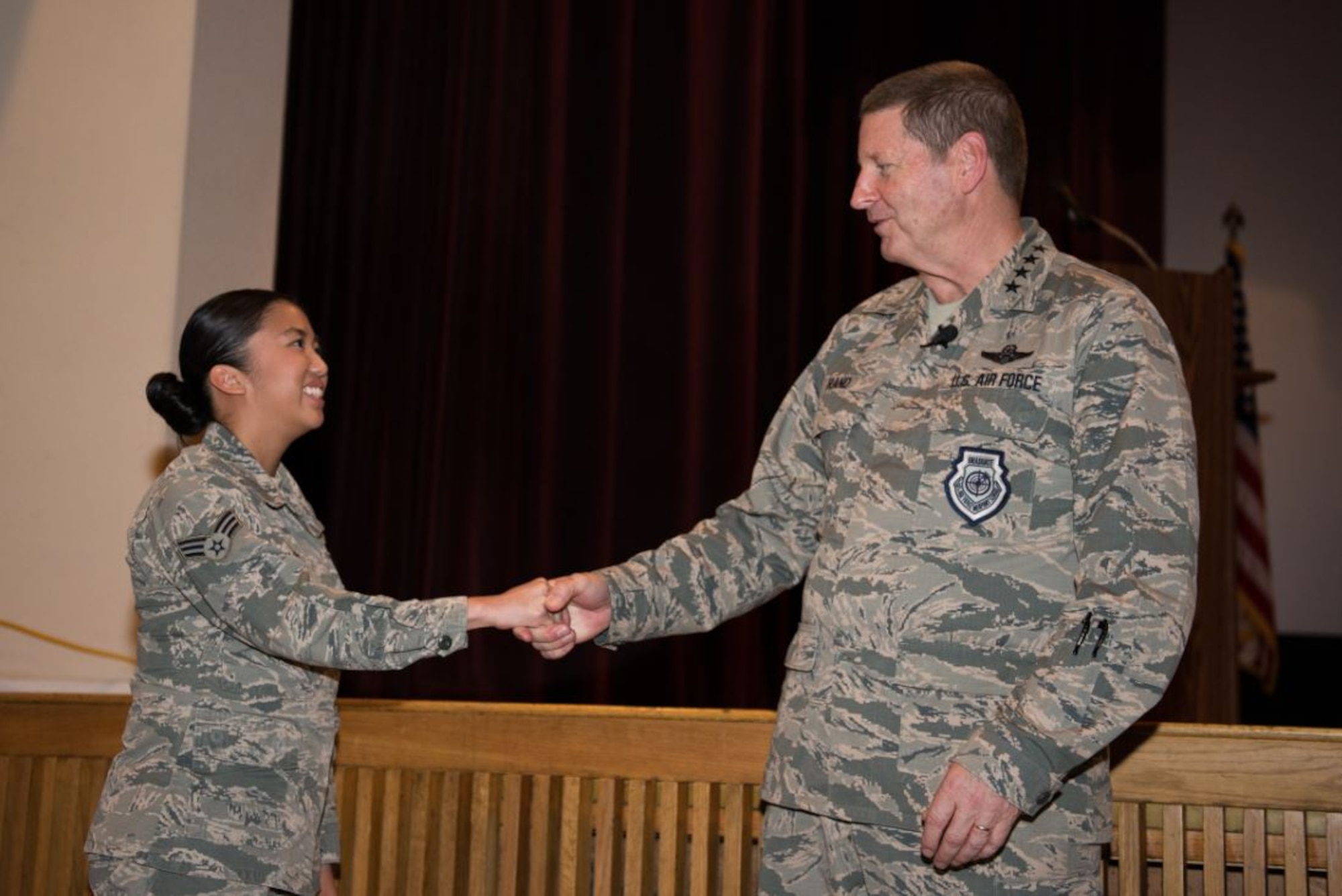 Gen. Robin Rand, AFGSC commander, recognizes Senior Airman Erika Santos, 5th Bomb Wing Command Post emergency actions controller, during an enlisted all call at Minot AFB, North Dakota. Rand recognized outstanding Airmen and civilians during the all call, which focused on his priorities as AFGSC’s commander. (U.S. Air Force photo/Airman 1st Class J.T. Armstrong)
