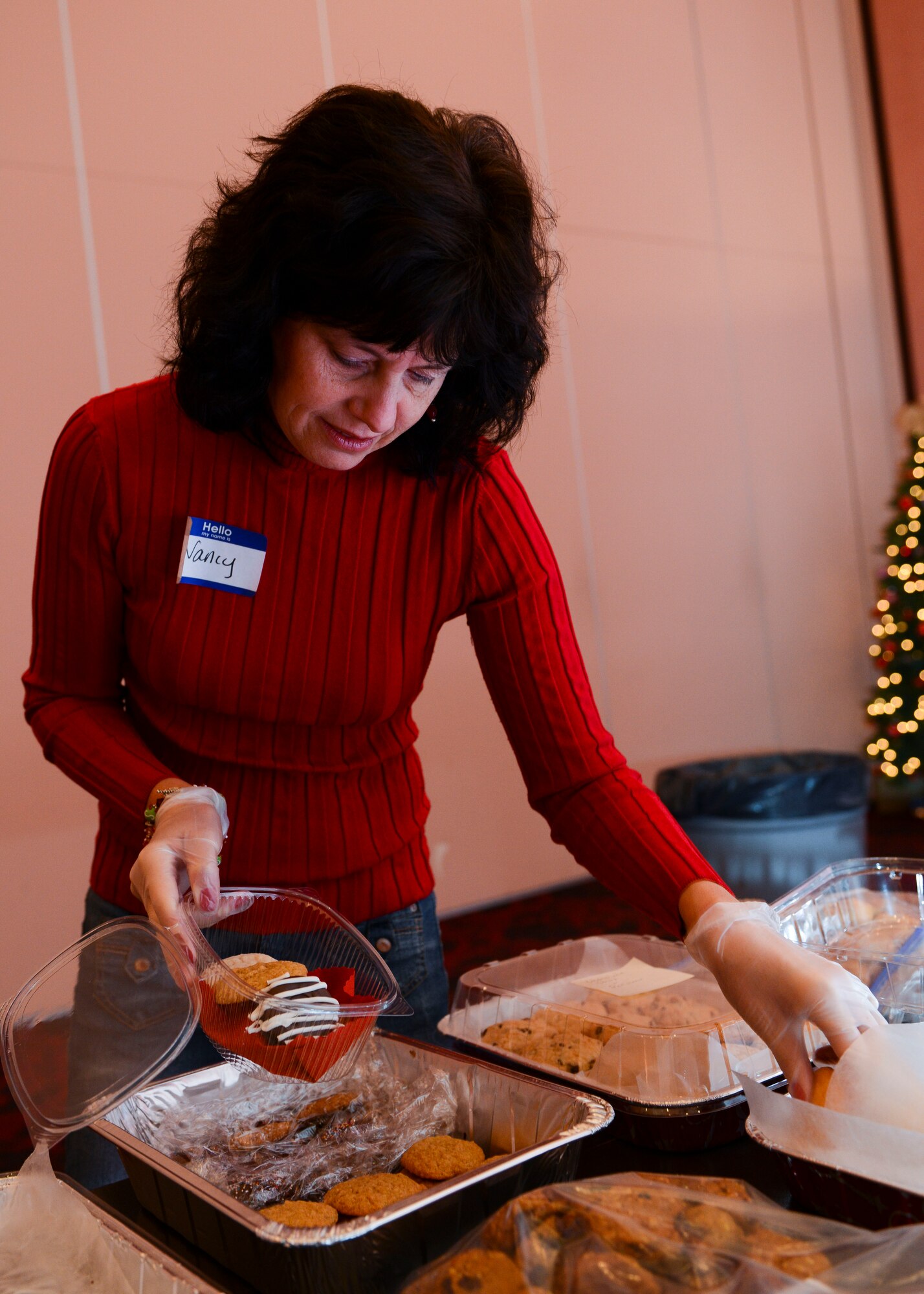 Nancy Seguin, 31st Fighter Wing key spouse, packs a box of cookies during the annual holiday cookie drive, Dec. 7, 2015, at Aviano Air Base, Italy. Team Aviano members donated the cookies, which were delivered to U.S. Air Force Airmen who live in the dormitories. (U.S. Air Force photo by Senior Airman Austin Harvill/Released)