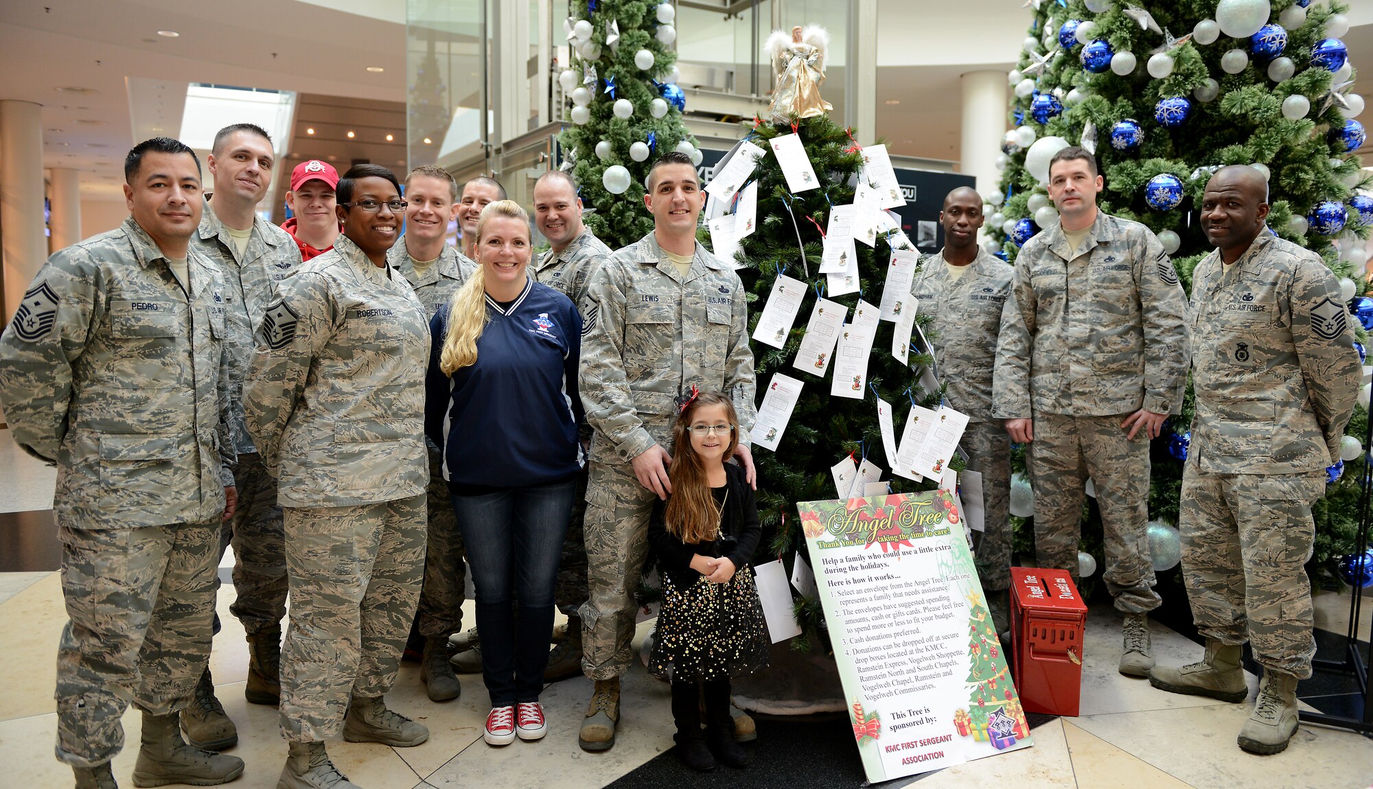 Caylee Lewis poses with her father, Master Sgt. Allen Lewis, 450th Intelligence Squadron first sergeant and Angel Tree 2015 chair, and other members of the Kaiserslautern Military Community First Sergeant Council during the Angel Tree 2015 kickoff Dec. 7, 2015, at Ramstein Air Base, Germany. Angel Tree is an outreach program designed to provide assistance to Airmen and their families throughout the KMC. (U.S. Air Force photo/Staff Sgt. Timothy Moore)