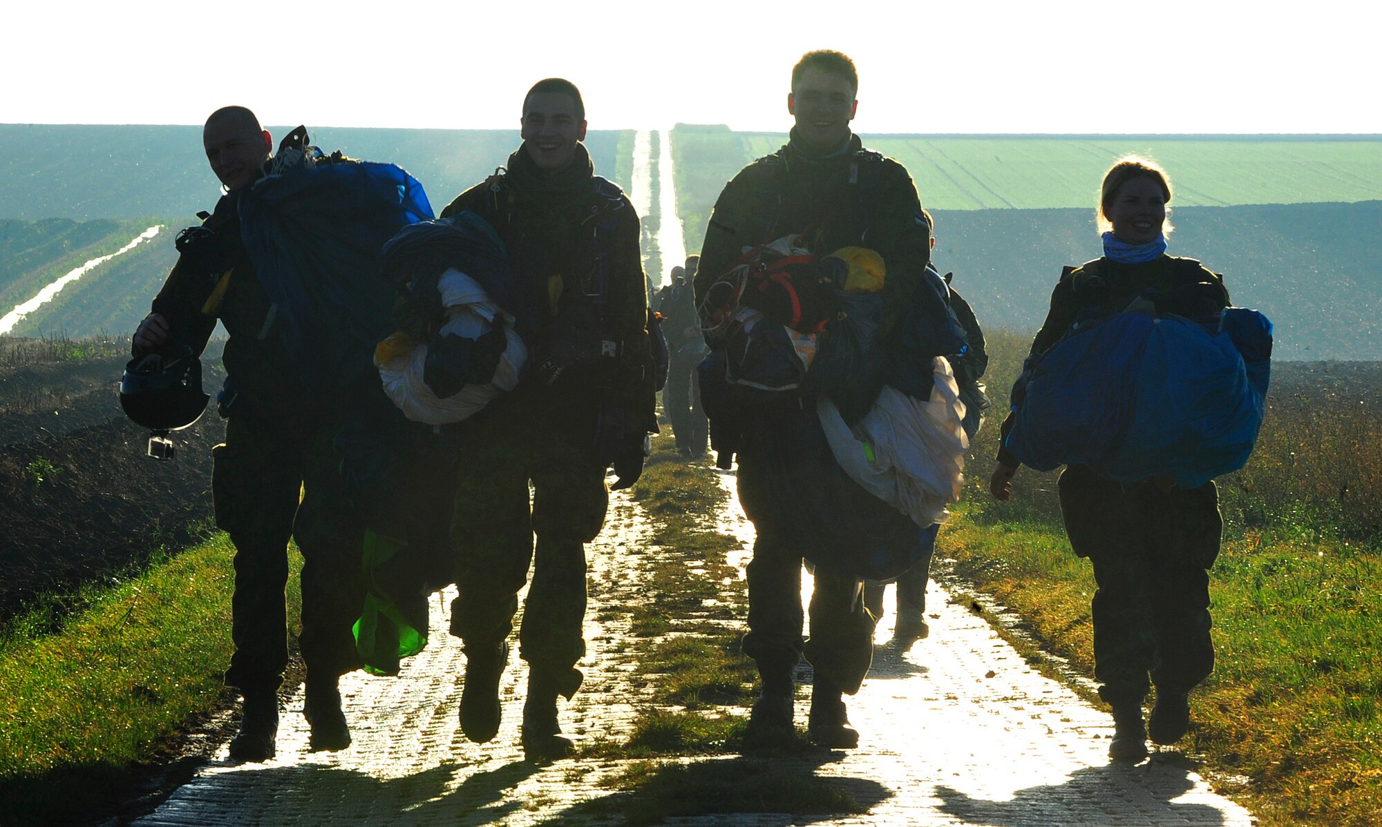 Estonian paratroopers carry their parachutes after landing during this year’s toy drop operation Dec. 7, 2015, at Alzey Drop Zone, Germany. NATO partners come together during International Jump Week to build partnerships by working together and building camaraderie and morale through the toy drop operation. Toy drop is a holiday event in which paratroopers donate and deliver toys to children in the community. (U.S. Air Force photo/Airman 1st Class Larissa Greatwood) 