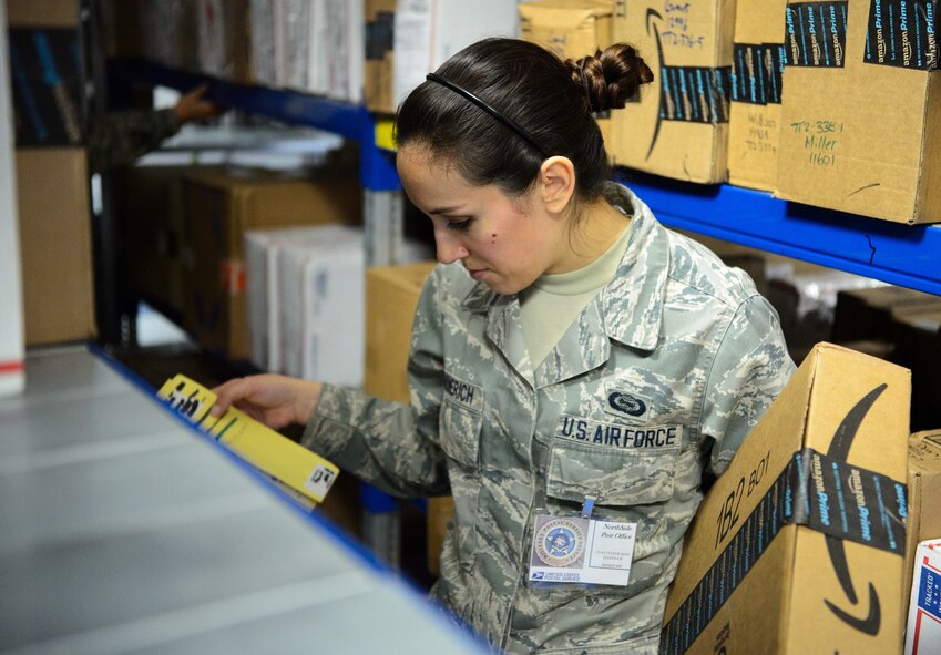 Senior Airman Bridgette Hemmerich, 450th Intelligence Squadron multi-source analyst, searches for a package at the Ramstein Northside Post Office Dec. 4, 2015, at Ramstein Air Base, Germany. Hemmerich coordinated the volunteer effort at the post office while other members of the 450th IS volunteered at a variety of locations around the Kaiserslautern Military Community. (U.S. Air Force photo/Staff Sgt. Armando A. Schwier-Morales)