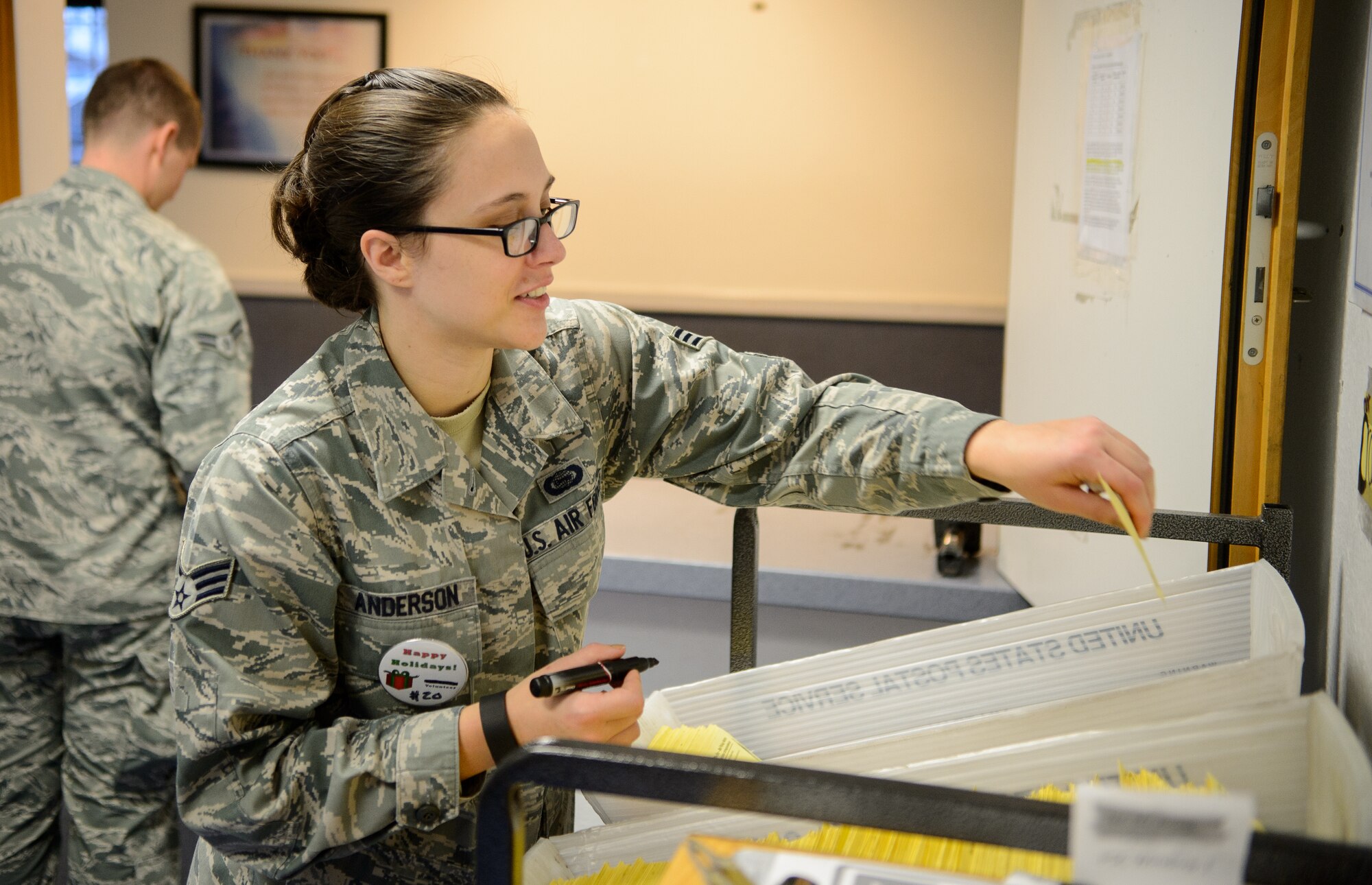 Senior Airman Carley Anderson, 450th Intelligence Squadron geospatial fusion analyst, marks slips for packages during Warbirds’ Service Day Dec. 4, 2015, at Ramstein Air Base, Germany. Anderson and more than 50 other Airmen provided 250 hours of service to a variety of organizations including the post office for their squadron service day. (U.S. Air Force photo/Staff Sgt. Armando A. Schwier-Morales)