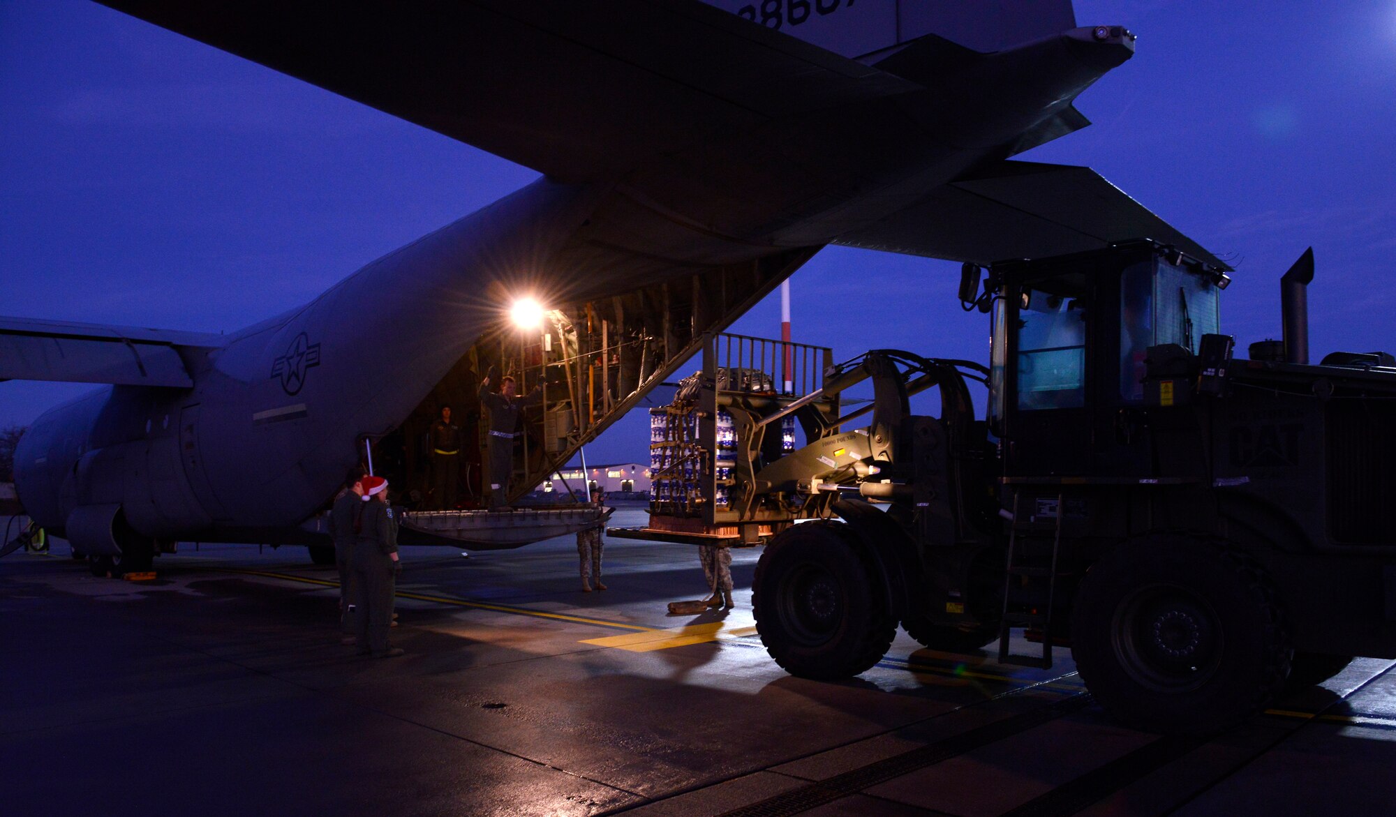 Airmen form the 37th Airlift Squadron and the 86th Logistic Readiness Squadron load a pallet of toys into a C-130J Super Hercules for an International Jump Week toy drop event Dec. 7, 2015, at Ramstein Air Base, Germany. Airmen, Soldiers, NATO members and Santa Claus parachuted out of the plane, along with the pallet of toys, at Alzey Drop Zone, Germany. (U.S. Air Force photo/Airman 1st Class Tryphena Mayhugh)