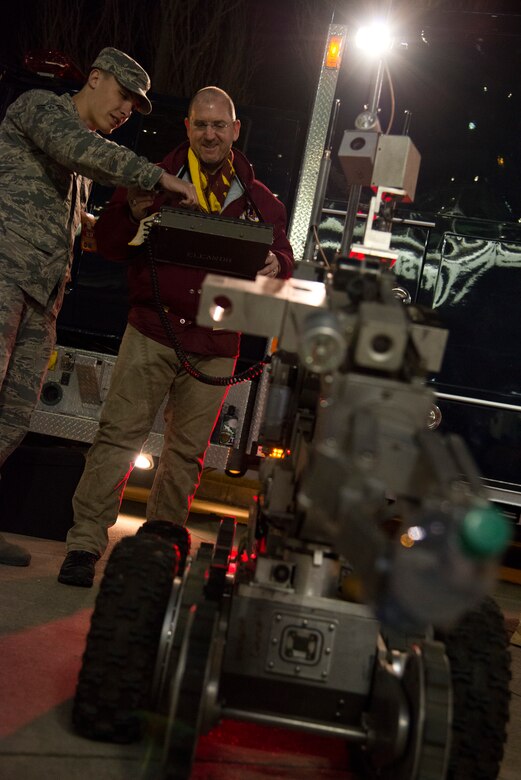 Wes Hummer, Washington Redskins fan, controls an ANDROS F6A explosive ordnance disposal robot outside FedEx Field Landover, Md., Dec. 7, 2015. The 11th Civil Engineer Squadron's EOD flight displayed capabilities to the public during a Redskins Salute night with Tech. Sgt. Christopher Ferrel, a member of the 11 CES, pinning on the Purple Heart medal during halftime of the football game. (U.S. Air Force photo by Airman 1st Class Philip Bryant/Released)