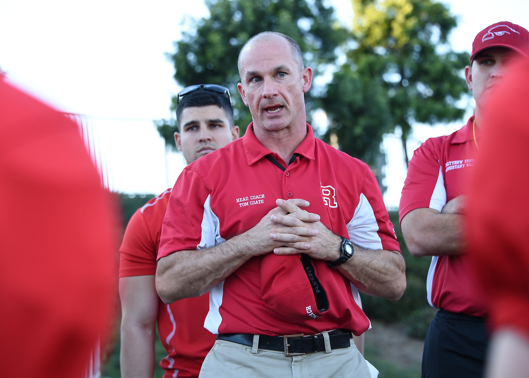 Lt. Col. Thomas Coate, backed up by two of his assistant coaches, Capt. Francisco Lugo (left) and Capt. Matthew Coates (right) from the Space and Missile Systems Center at Los Angeles Air Force Base in El Segundo, Calif., addresses his players during a recent semi-final football game. Over the last four years, Coate has managed to recruit over twenty active-duty and civilian personnel as volunteers for the local Pop Warner football team in Redondo Beach, Calif.  (U.S. Air Force photo/Joe Juarez Sr.)
