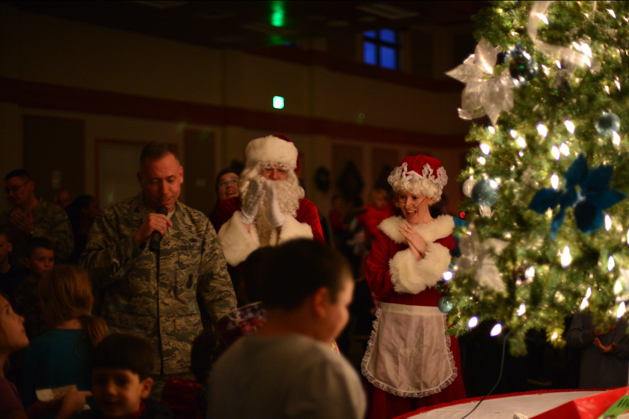 Col. Tom Wilcox, 341st Missile Wing commander, with the assistance from Mr. and Mrs. Claus, light a tree to signify the start of the holiday season Dec. 2, 2015, at Malmstrom Air Force Base, Mont. The event included refreshments, a gift shop for kids to purchase presents for their family and a holiday card contest announcement of the winners. (U.S. Air Force photo/Airman Daniel Brosam)