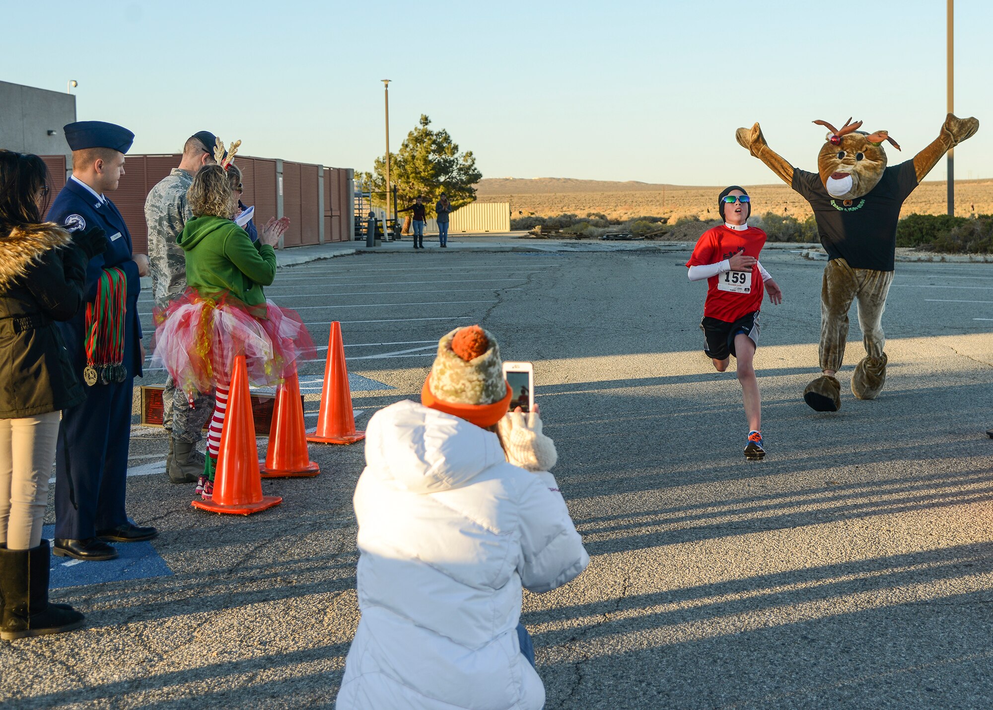 Overall winner and top under 12 finisher, Zack Gilbertson, came in with a time of 20:09. As he crossed the finish line Edward the Reindeer ran in behind him. (U.S. Air Force photo by Rebecca Amber)