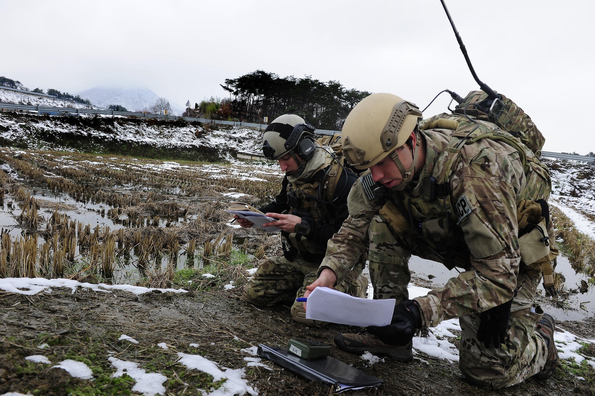 Senior Airman William Irvin, 604th Air Support Operations Squadron joint terminal air controller, and 1st. Lt. Austin Hairfield, 604th ASOS tactical air control party officer in charge, coordinate close air support during Exercise Woody Cloud 16-1, Dec. 4, 2015. Exercise Woody Cloud 16-1 was the first-ever exercise that allowed pilots and JTAC Airmen to train side by side. (U.S. Air Force photo by Staff Sgt. Nick Wilson/Released)