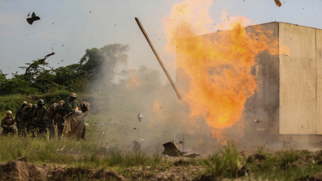 A Uganda People’s Defense Force soldier detonates an "oval charge" on desired entry point during a breaching exercise at Camp Singo, Dec. 8, 2015. The Marines and UPDF improved breaching capabilities as they prepare for their African Union Mission in Somalia. 