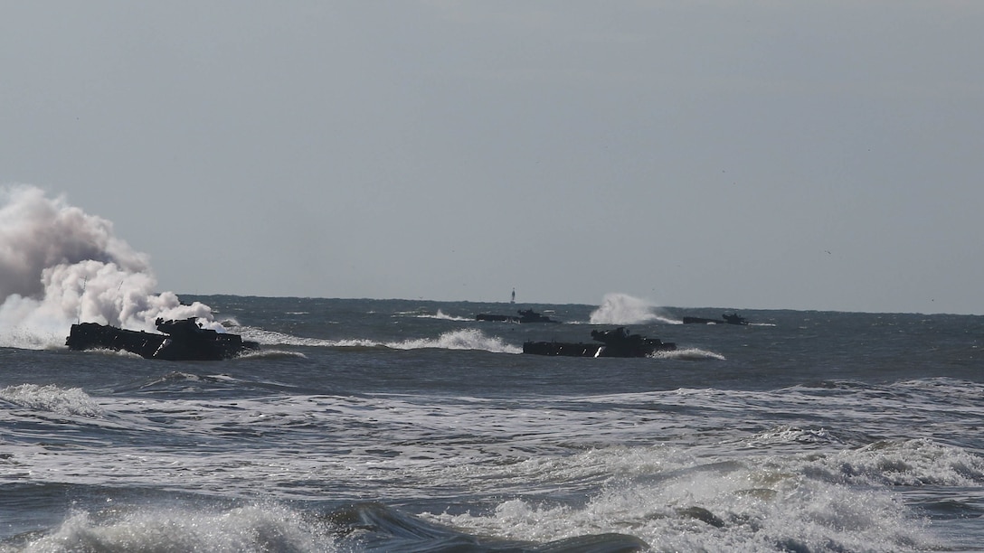 A wave of Amphibious Assault Vehicles with Alpha Company, 2nd Assault Amphibian Battalion, storms the beach as part of company-level beach operations on Marine Corps Base Camp Lejeune, N.C., Dec. 5, 2015. During the exercise Marines within the unit had the opportunity to work with platoons that they never had before.