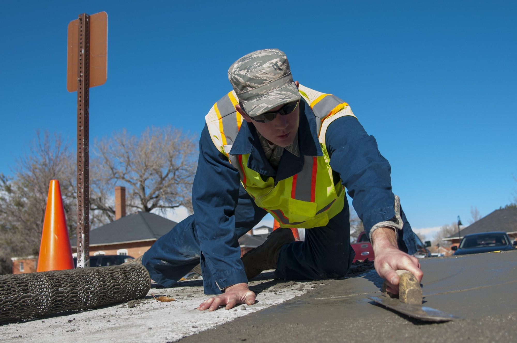 Staff Sgt. Justin Morrison, 90th Civil Engineer Squadron Pavements and Equipment, smooth’s out concrete poured outside the Chadwell Dining Facility on F.E. Warren Air Force Base, Wyo., Nov. 10, 2015. The concrete replaced gravel that pedestrians often kicked into the roads, posing wear and tear issues for the road. (U.S. Air Force photo by Senior Airman Jason Wiese)