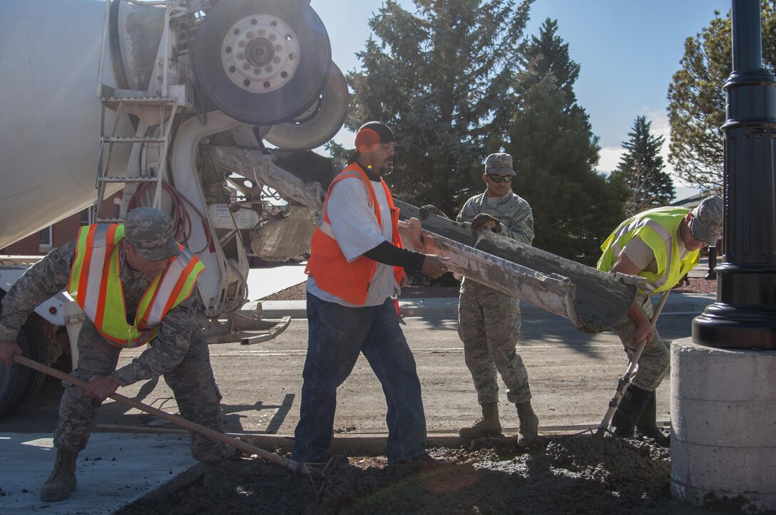 90th Civil Engineer Squadron Airmen work to fill in an area with concrete outside the Chadwell Dining Facility on F.E. Warren Air Force Base, Wyo., Nov. 10, 2015. It takes coordination from many different agencies to take a CE project from cradle to the grave. (U.S. Air Force photo by Senior Airman Jason Wiese)