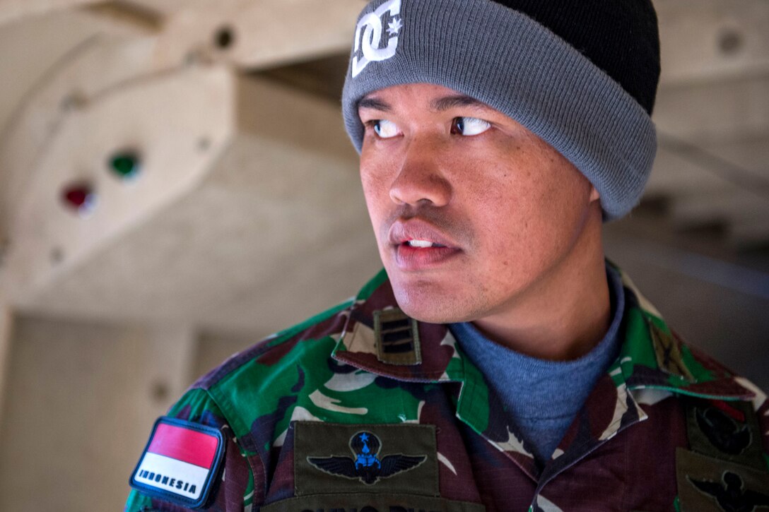 Indonesian Capt. Agung Setyawan performs jumpmaster duties during the 18th Annual Randy Oler Memorial Operation Toy Drop on Camp Mackall, N.C., Dec. 7, 2015. Operation Toy Drop is the world's largest combined airborne operation during which service members help provide children in need with toys for the holidays.  U.S. Air Force photo by Staff Sgt. Douglas Ellis