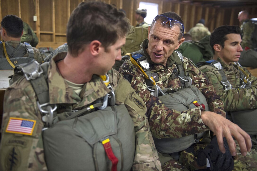 Italian jumpmaster Lt. Valter Sergo, center, talks with a U.S. Army paratrooper during the 18th Annual Randy Oler Memorial Operation Toy Drop on Camp Mackall, N.C., Dec. 7, 2015. U.S. Air Force photo by Staff Sgt. Douglas Ellis
