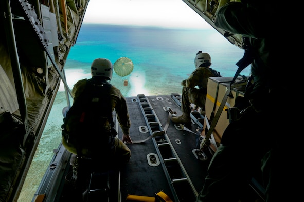 Australian Army Cpl. Teome Matamua and Sgt. Phillip McIllvaney, 176th Air Dispatch Squadron loadmasters, deliver the first low-cost, low-altitude bundle of Operation Christmas Drop 2015 to the island of Mogmog, Dec. 8, 2015. Australian and Japanese C-130 Hercules aircrews for the first time joined U.S. Airmen during the 64th year of Operation Christmas Drop which provided critical supplies to 56 islands throughout the Commonwealth of the Northern Marianas Islands, Federated States of Micronesia and Republic of Palau. It highlighted the U.S. and allied airpower capabilities to orient and respond to activities in peacetime and crisis. (U.S. Air Force photo/Staff Sgt. Katrina Brisbin)