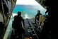 Australian Army Cpl. Teome Matamua and Sgt. Phillip McIllvaney, 176th Air Dispatch Squadron loadmasters, deliver the first low-cost, low-altitude bundle of Operation Christmas Drop 2015 to the island of Mogmog, Dec. 8, 2015. Australian and Japanese C-130 Hercules aircrews for the first time joined U.S. Airmen during the 64th year of Operation Christmas Drop which provided critical supplies to 56 islands throughout the Commonwealth of the Northern Marianas Islands, Federated States of Micronesia and Republic of Palau. It highlighted the U.S. and allied airpower capabilities to orient and respond to activities in peacetime and crisis. (U.S. Air Force photo/Staff Sgt. Katrina Brisbin)
