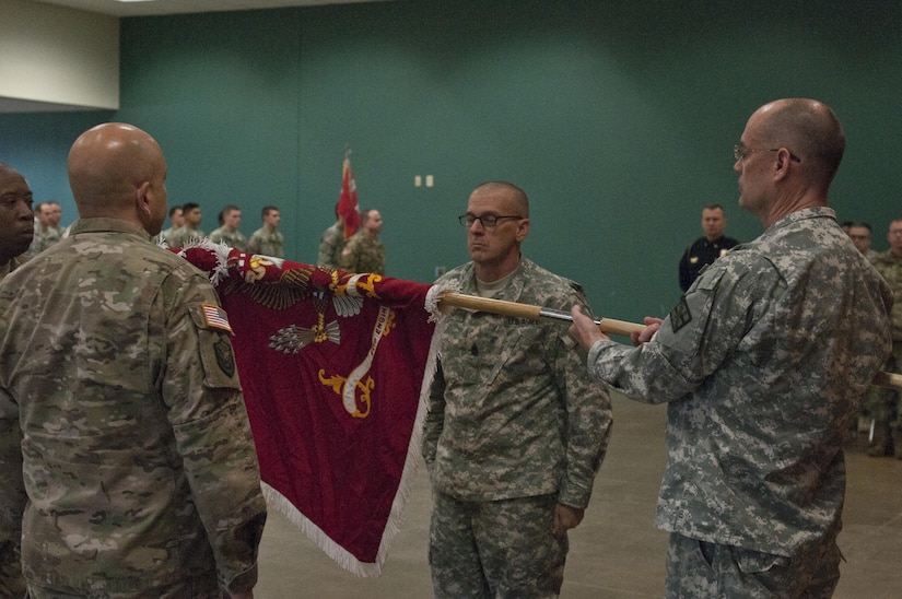U.S. Army Reserve Col. Ralph Henning, commander, 411th Engineer Brigade unfurls the 363rd Engineer Battalion's flag during the 363rd's activation ceremony Dec. 5 in Knightdale, N.C. (U.S. Army photo by Staff Sgt. Debralee Best)