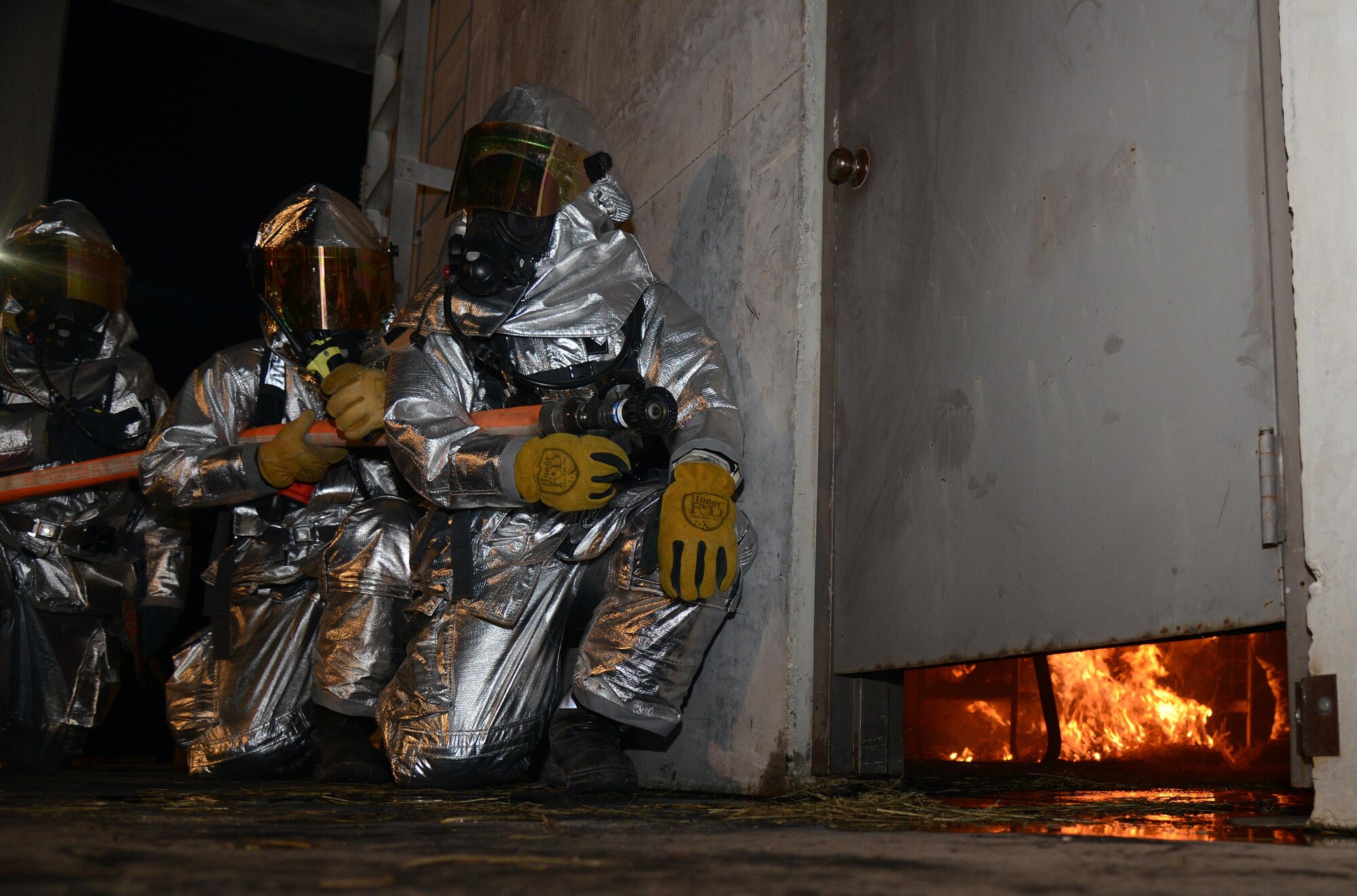 Firefighters from the 47th Civil Engineer Squadron prepare to enter the fire-training structure on Laughlin Air Force Base, Texas, Nov. 18, 2015. The training consisted of a first-floor fire and involved practicing multiple techniques. (U.S. Air Force photo by Airman 1st Class Brandon May)
