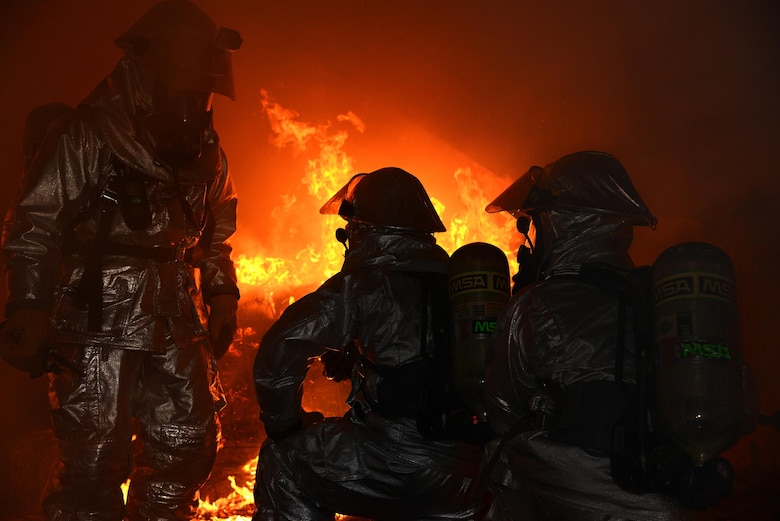 Tech. Sgt. Joshua Lewis, 47th Civil Engineer Squadron station captain, left, speaks to two firefighters during a training exercise on Laughlin Air Force Base, Texas,  Nov. 18, 2015. The training was used to improve the firefighters’ techniques and promote proper safety procedures. (U.S. Air Force photo by Airman 1st Class Brandon May)