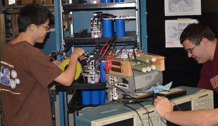 BLACKSBURG, Va. - Virginia Tech students studying electromagnetic railgun technology are pictured during a break in their work at the university's Energy Conversion Systems Laboratory. Naval Surface Warfare Center Dahlgren Division scientists and engineers mentored the students who fired Virginia Tech's electromagnetic railgun for the first time Dec. 4. The university's reduced-scale railgun program attracted more than 150 students from all engineering disciplines to participate in hands-on railgun research.