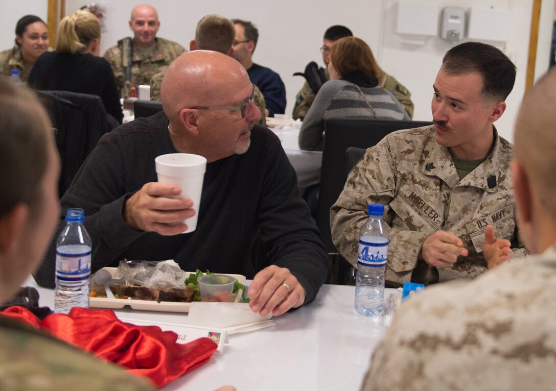 Singer and songwriter Billy Montana has lunch with a U.S. Marine during a visit by the 2015 USO Holiday Tour to Bagram Airfield, Afghanistan, Dec. 8, 2015. USO entertainers were traveling to various locations to visit deployed service members. DoD photo by D. Myles Cullen