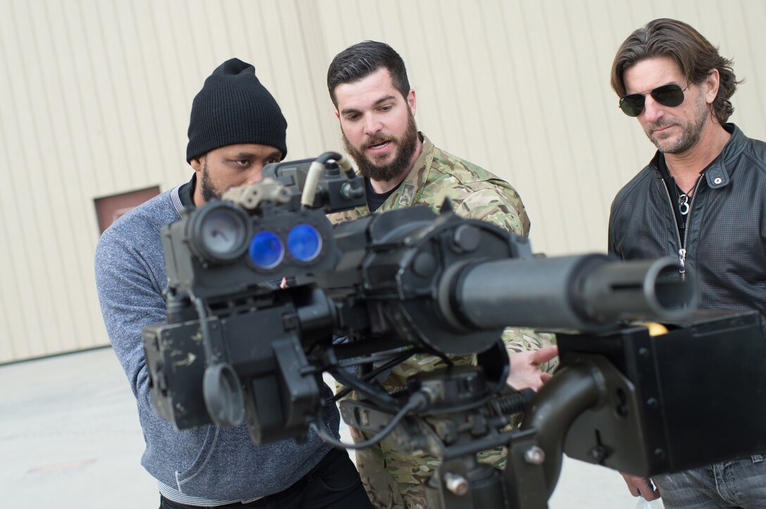 Comedian Sydney Castillo is shown a weapons system utilized by U.S. special operations forces during a visit by the 2015 USO Holiday Tour to Bagram Airfield, Afghanistan, Dec. 8, 2015. USO entertainers were traveling to various locations to visit deployed service members. DoD photo by D. Myles Cullen