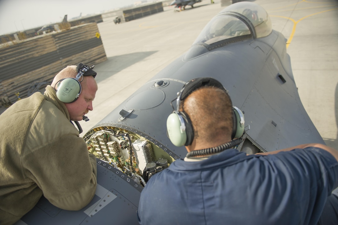 U.S. Air Force Senior Airman Jason Miranda, left, and U.S. Air Force Tech. Sgt. Carlo Patalinghug examine an F-16 Fighting Falcon while repairing a hydraulic leak on the aircraft's leading edge flap on Bagram Airfield, Afghanistan, Nov. 30, 2015. Miranda and Patalinghug are crew chiefs assigned to the 455th Expeditionary Aircraft Maintenance Squadron, deployed from Hill Air Force Base, Utah. U.S. Air Force photo by Tech. Sgt. Robert Cloys