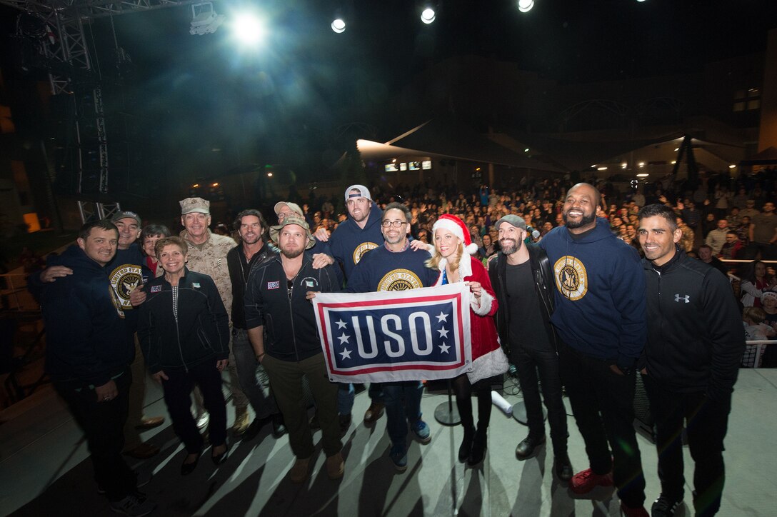 U.S. Marine Corps Gen. Joseph F. Dunford Jr., chairman of the Joint Chiefs of Staff, his wife, Ellyn Dunford, and performers with the 2015 USO Holiday Tour take a group photo with the audience at Naval Support Activity Bahrain, Dec. 7, 2015. DoD photo by D. Myles Cullen