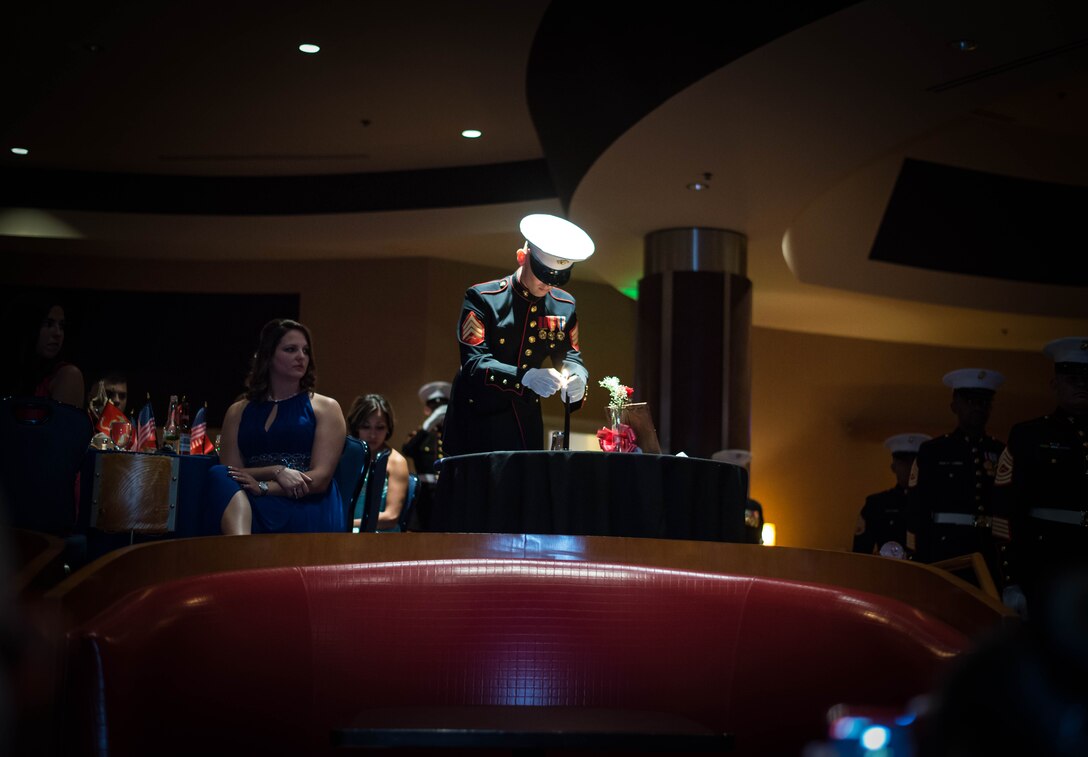 Sgt. Braydon Clendenning, from the 12th Marine Corps District Admin Office, lights a candle on the Prisoner of War/Missing in Action table setting in honor of the sacrifices Marines have made throughout history, during the 12th MCD’s ball ceremony in San Diego, Ca. Nov. 6, 2015. (Photo provided by SSgt. Joseph Ford)