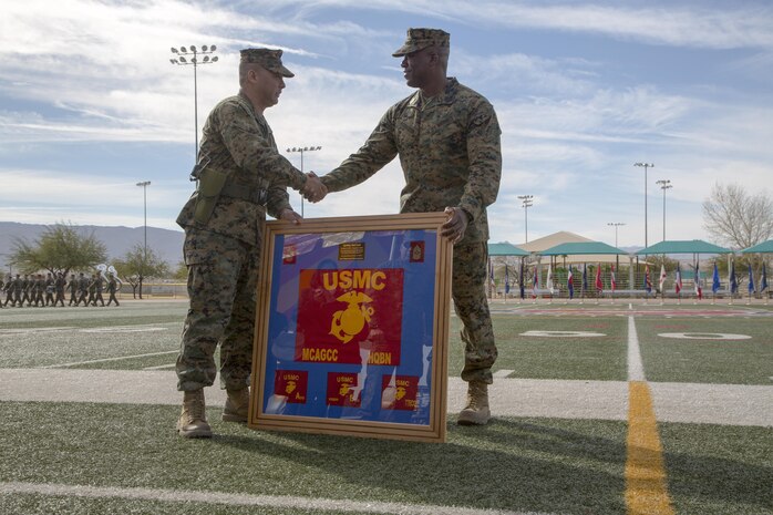 Sgt. Maj. Abel T. Leal, former battalion sergeant major, Headquarters Battalion, receives a plaque from 1st Sgt. Frank O. Robinson, Company A First Sergeant, Headquarters Battalion, during a relief and appointment ceremony at Felix Field, Dec. 3, 2015. Leal served as the battalion’s sergeant major since October of 2013 and was relieved by Sgt. Maj. Avery L. Crespin. (Official Marine Corps photo by Pfc. Allie Jesse/Released)