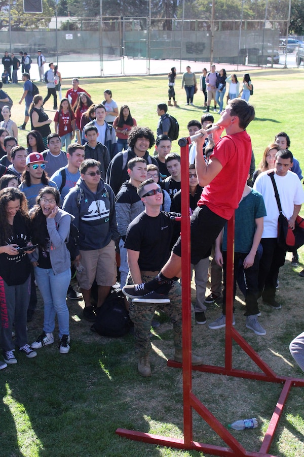 Sgt. Weldon B. Housley, recruiter of Recruiting Sub Station Ventura, observes as a Santa Paula High School student performs pull-ups during the pull-up challenge at an ASA High School Tour event, Dec. 8, 2015, in Santa Paula, Calif. ASA brings in five of the world's top professional skateboarders, inline skaters and BMX riders from the X Games to perform on a state-of-the art half-pipe. Marines from RSS Ventura supported the event to inform students about the Marine Corps, and conduct a pull-up challenge. (U.S. Marine Corps photo by Staff Sgt. Alicia R. Leaders/Released)