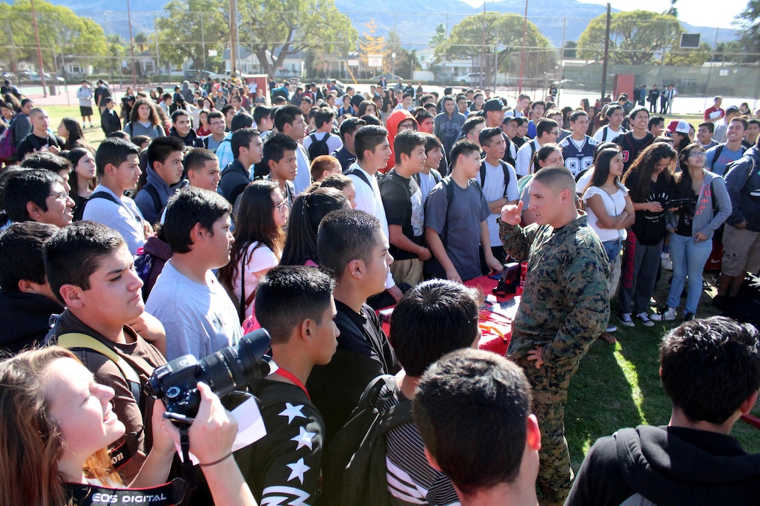 Staff Sgt. Edwin O. Salvatierra, staff noncommissioned officer in charge of Recruiting Sub Station Ventura, talks to Santa Paula High School students during an ASA High School Tour event, Dec. 8, 2015, in Santa Paula, Calif. ASA brings in five of the world's top professional skateboarders, inline skaters and BMX riders from the X Games to perform on a state-of-the art half-pipe. Marines from RSS Ventura supported the event to inform students about the Marine Corps, and conduct a pull-up challenge. (U.S. Marine Corps photo by Staff Sgt. Alicia R. Leaders/Released)